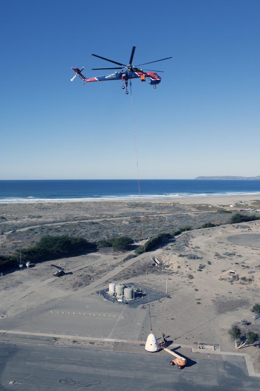MORRO BAY, Calif. – A SpaceX Dragon test article is lifted under an Erickson Sky Crane helicopter before a test to evaluate the spacecraft's parachute deployment system as part of a milestone achievement under its Commercial Crew Integrated Capability agreement with NASA's Commercial Crew Program. The parachute test took place over the Pacific Ocean, off the coast of Morro Bay, Calif. Photo credit: NASA/Kim Shiflett