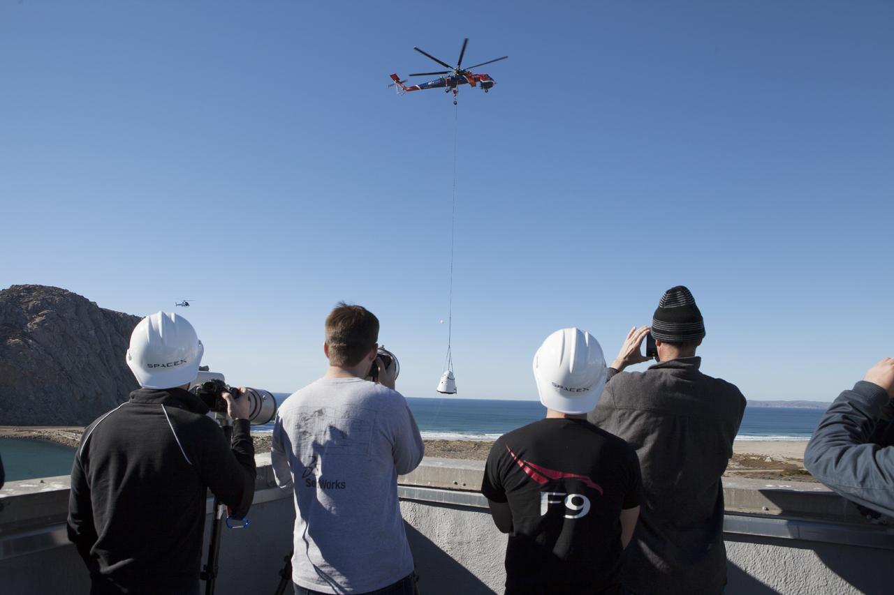 An Erickson Sky Crane helicopter returns the SpaceX Dragon test article to Morro Bay, Cailf., following a test to evaluate the spacecraft's parachute deployment system. The test was part of a milestone under its Commercial Crew Integrated Capability agreement  with NASA's Commercial Crew Program. Photo credit: NASA/Kim Shiflett