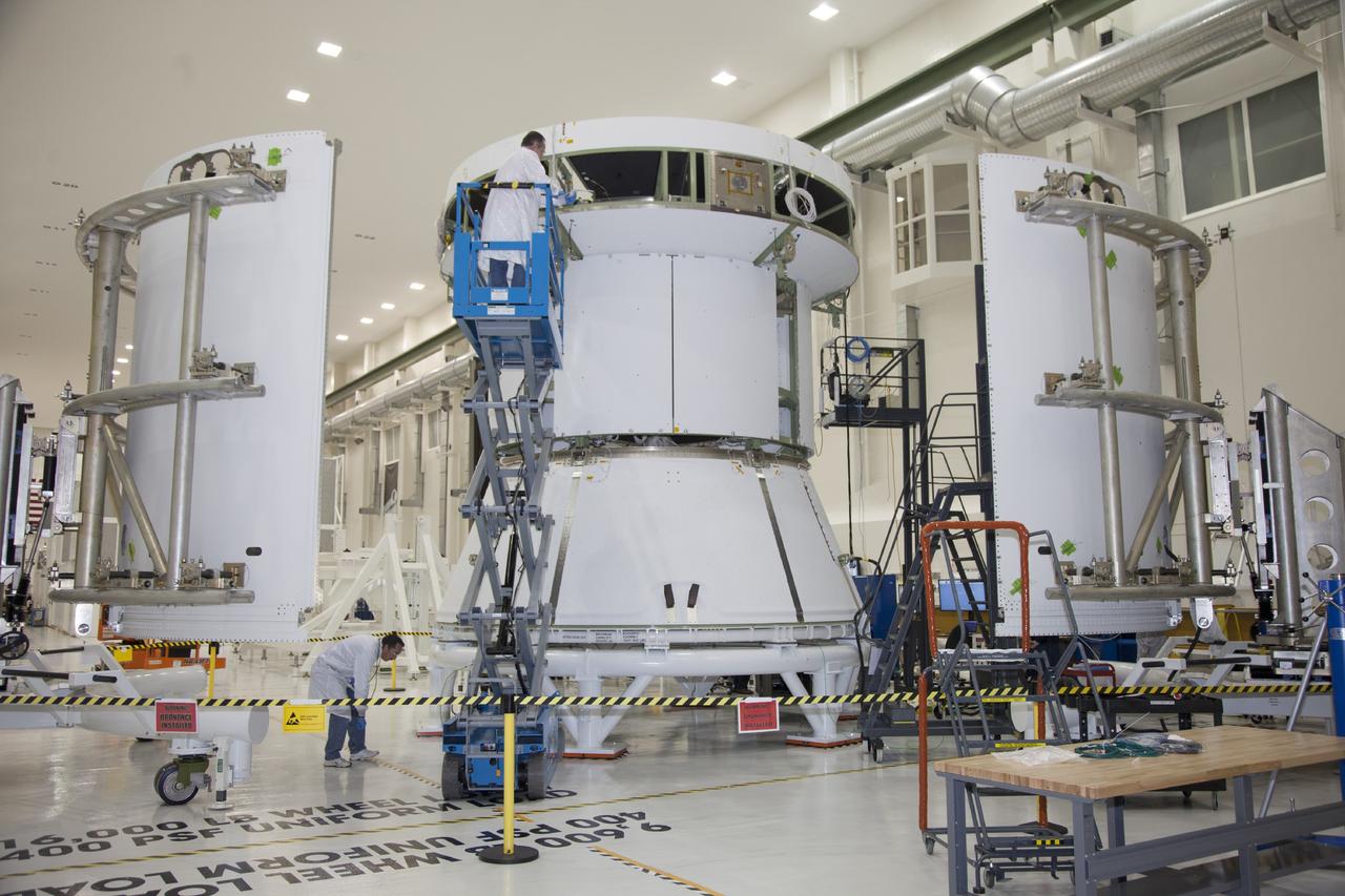 CAPE CANAVERAL, Fla. – Inside the Operations and Checkout Building high bay at NASA’s Kennedy Space Center in Florida, a technician on a scissor lift works on the service module for the Orion spacecraft. To the right and left are two of the three fairings that will be installed around the service module.    The Orion spacecraft is being prepared for its first unpiloted flight test, Exploration Flight Test-1, or EFT-1, scheduled for launch atop a Delta IV rocket in September 2014. The Orion spacecraft is designed to carry astronauts to destinations not yet explored by humans. It will have emergency abort capability, sustain the crew during space travel and provide safe re-entry from deep space return velocities. Orion is scheduled to launch atop NASA’s Space Launch System rocket in 2017. For more information, visit http://www.nasa.gov/orion. Photo credit: NASA/Daniel Casper