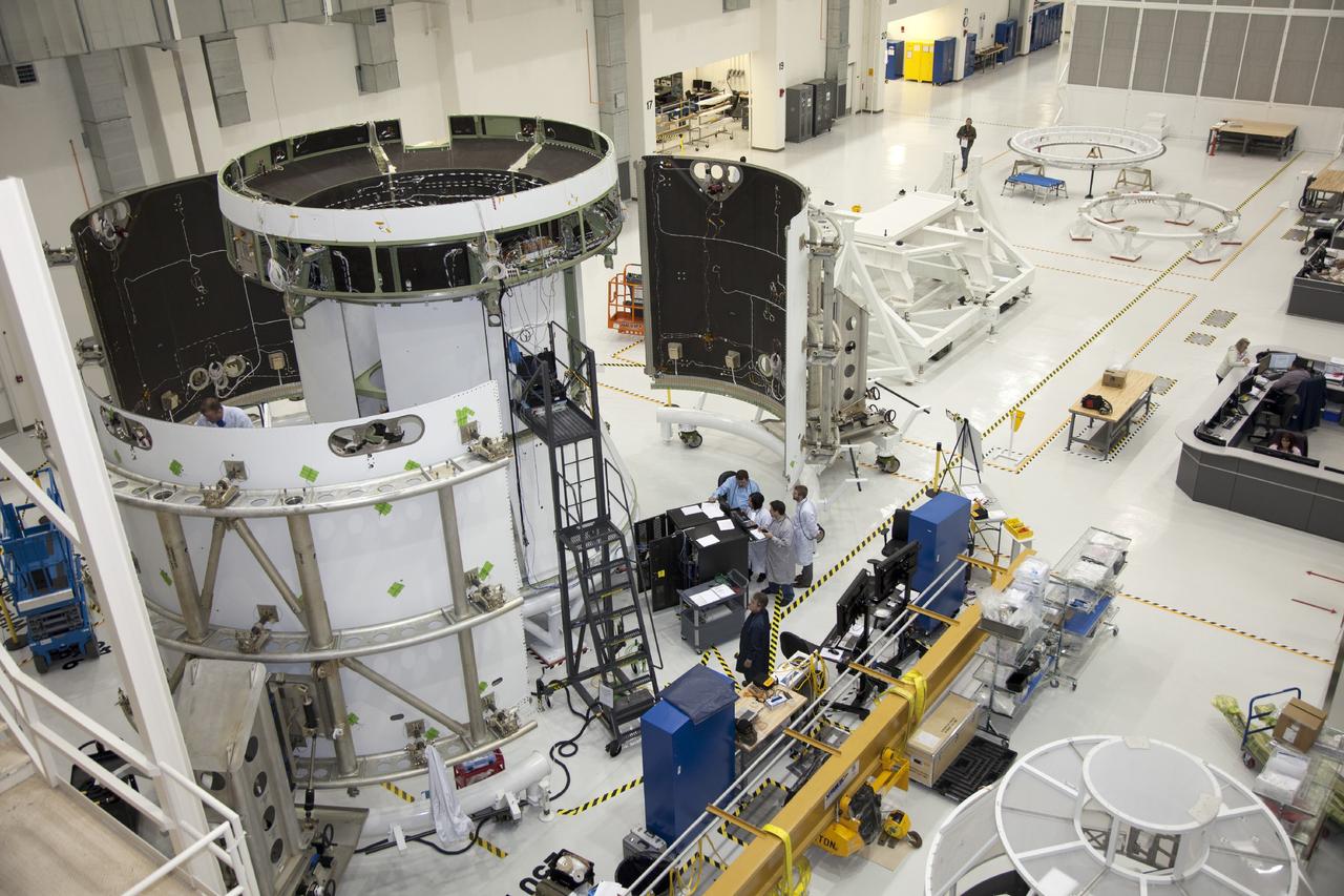CAPE CANAVERAL, Fla. – A view from above inside the Operations and Checkout Building high bay at NASA’s Kennedy Space Center in Florida, shows the service module for the Orion spacecraft secured to a work stand. Technicians are preparing the three fairings for installation around the service module.     The Orion spacecraft is being prepared for its first unpiloted flight test, Exploration Flight Test-1, or EFT-1, scheduled for launch atop a Delta IV rocket in September 2014. The Orion spacecraft is designed to carry astronauts to destinations not yet explored by humans. It will have emergency abort capability, sustain the crew during space travel and provide safe re-entry from deep space return velocities. Orion is scheduled to launch atop NASA’s Space Launch System rocket in 2017. For more information, visit http://www.nasa.gov/orion. Photo credit: NASA/Daniel Casper