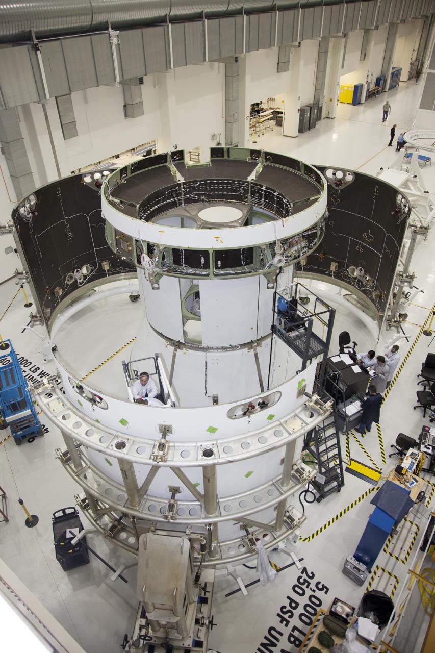 CAPE CANAVERAL, Fla. – A view from above inside the Operations and Checkout Building high bay at NASA’s Kennedy Space Center in Florida, shows the service module for the Orion spacecraft secured to a work stand. Technicians are preparing the three fairings for installation around the service module.     The Orion spacecraft is being prepared for its first unpiloted flight test, Exploration Flight Test-1, or EFT-1, scheduled for launch atop a Delta IV rocket in September 2014. The Orion spacecraft is designed to carry astronauts to destinations not yet explored by humans. It will have emergency abort capability, sustain the crew during space travel and provide safe re-entry from deep space return velocities. Orion is scheduled to launch atop NASA’s Space Launch System rocket in 2017. For more information, visit http://www.nasa.gov/orion. Photo credit: NASA/Daniel Casper