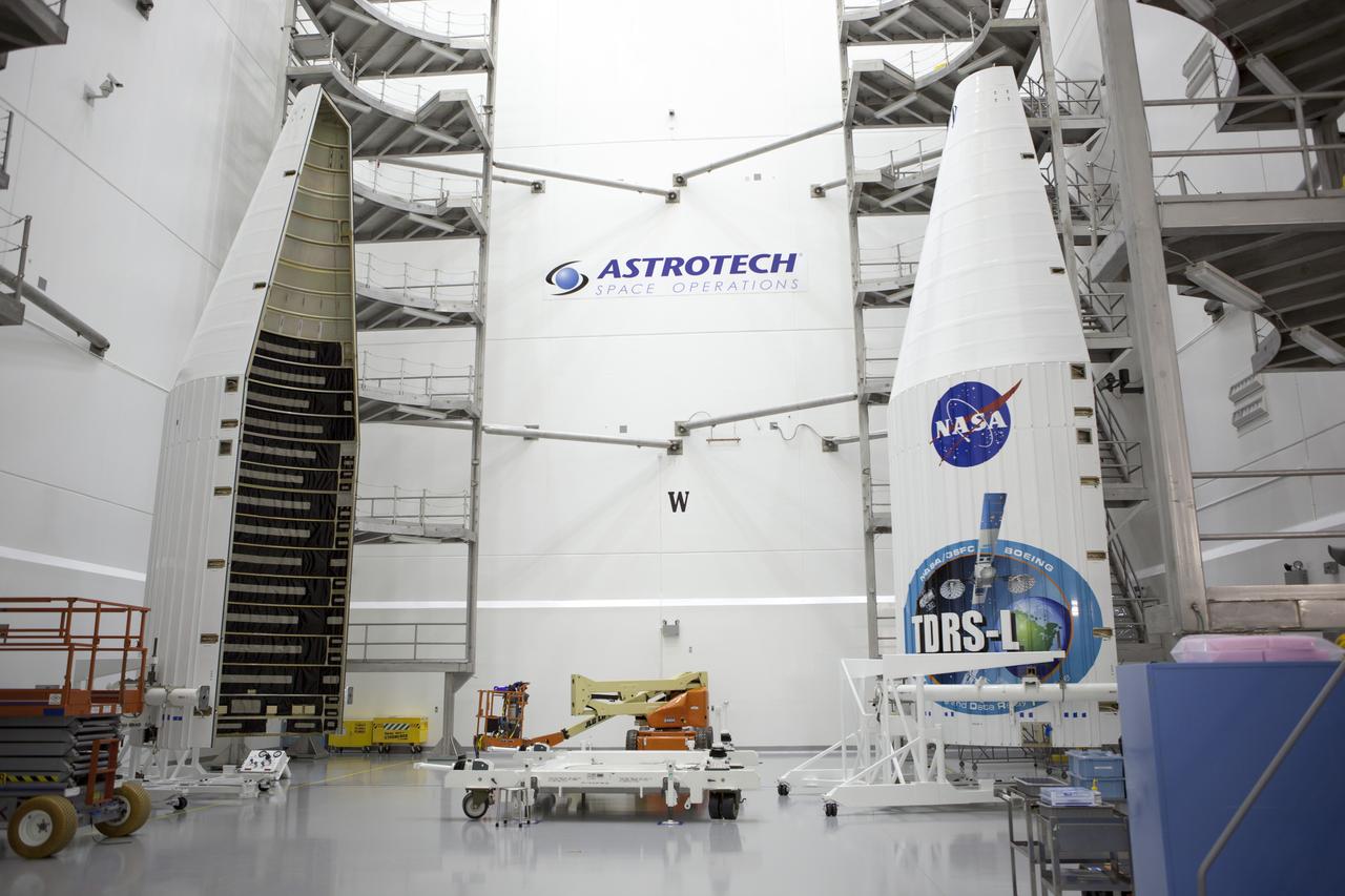 TITUSVILLE, Fla. – Inside the Astrotech payload processing facility in Titusville, members of the news media are given an opportunity for an up-close look at the payload fairing that will encapsulate the Tracking and Data Relay Satellite, or TDRS-L, spacecraft. Journalists visited Astrotech as part of TDRS-L Media Day to conduct interviews and photograph the satellite that will be a part of the second of three next-generation spacecraft designed to ensure vital operational continuity for the NASA Space Network. It is scheduled to launch from Cape Canaveral's Space Launch Complex 41 atop an Atlas V rocket in January 2014. The current Tracking and Data Relay Satellite system consists of eight in-orbit satellites distributed to provide near continuous information relay contact with orbiting spacecraft ranging from the International Space Station and Hubble Space Telescope to the array of scientific observatories. For more information, visit: http://www.nasa.gov/mission_pages/tdrs/home/index.html