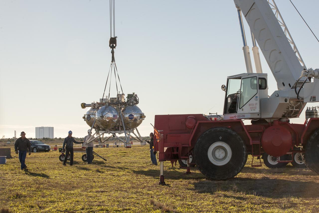 CAPE CANAVERAL, Fla. – Engineers and technicians prepare the Project Morpheus prototype lander for its third free flight test at the north end of the Shuttle Landing Facility at NASA’s Kennedy Space Center in Florida. The 57-second test began at 1:15 p.m. EST with the Morpheus lander launching from the ground over a flame trench and ascending about 187 feet, nearly doubling the target ascent velocity from the last test in December 2013. The lander flew forward, covering about 154 feet in 20 seconds before descending and landing within 11 inches of its target on a dedicated pad inside the autonomous landing and hazard avoidance technology, or ALHAT, hazard field. Project Morpheus tests NASA’s ALHAT and an engine that runs on liquid oxygen and methane, or green propellants, into a fully-operational lander that could deliver cargo to other planetary surfaces. The landing facility provides the lander with the kind of field necessary for realistic testing, complete with rocks, craters and hazards to avoid. Morpheus’ ALHAT payload allows it to navigate to clear landing sites amidst rocks, craters and other hazards during its descent. Project Morpheus is being managed under the Advanced Exploration Systems, or AES, Division in NASA’s Human Exploration and Operations Mission Directorate. The efforts in AES pioneer new approaches for rapidly developing prototype systems, demonstrating key capabilities and validating operational concepts for future human missions beyond Earth orbit. For more information on Project Morpheus, visit http://www.nasa.gov/centers/johnson/exploration/morpheus. Photo credit: NASA/Kim Shiflett  