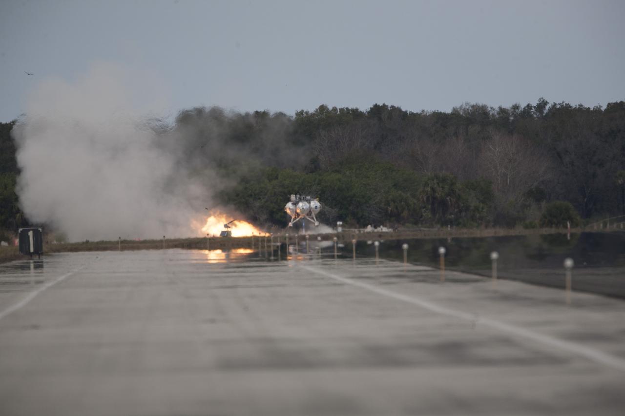 CAPE CANAVERAL, Fla. – The Project Morpheus prototype lander’s fourth free flight test begins at the north end of the Shuttle Landing Facility at NASA’s Kennedy Space Center in Florida. The 64-second test began at 1:15 p.m. EST with the Morpheus lander launching from the ground over a flame trench and ascending about 305 feet, significantly increasing the ascent velocity from the last test. The lander flew forward, covering about 358 feet in 25 seconds before descending and landing within 15 inches of its target on a dedicated pad inside the autonomous landing and hazard avoidance technology, or ALHAT, hazard field. Project Morpheus tests NASA’s ALHAT and an engine that runs on liquid oxygen and methane, or green propellants, into a fully-operational lander that could deliver cargo to other planetary surfaces. The landing facility provides the lander with the kind of field necessary for realistic testing, complete with rocks, craters and hazards to avoid. Morpheus’ ALHAT payload allows it to navigate to clear landing sites amidst rocks, craters and other hazards during its descent. Project Morpheus is being managed under the Advanced Exploration Systems, or AES, Division in NASA’s Human Exploration and Operations Mission Directorate. The efforts in AES pioneer new approaches for rapidly developing prototype systems, demonstrating key capabilities and validating operational concepts for future human missions beyond Earth orbit. For more information on Project Morpheus, visit http://www.nasa.gov/centers/johnson/exploration/morpheus. Photo credit: NASA/Kim Shiflett