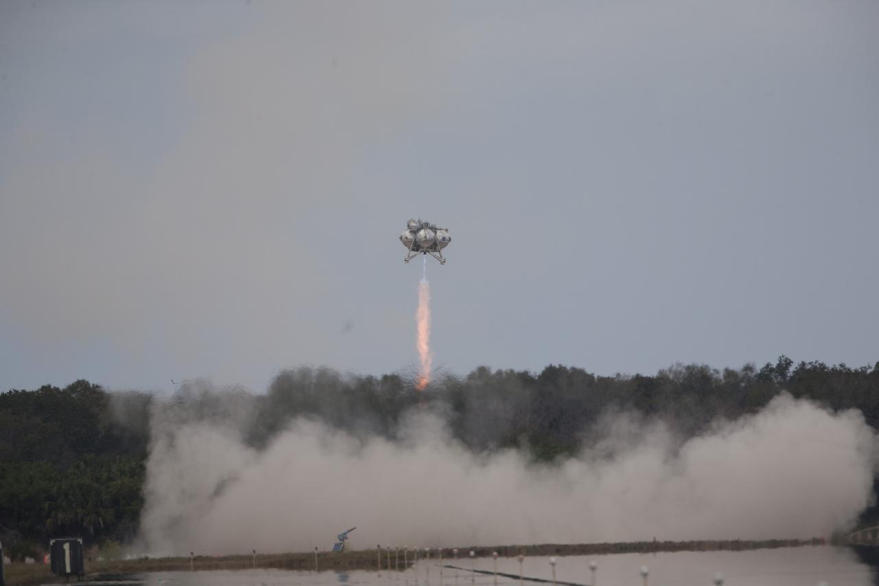 CAPE CANAVERAL, Fla. – The Project Morpheus prototype continues to ascend after launching on its fourth free flight test at the north end of the Shuttle Landing Facility at NASA’s Kennedy Space Center in Florida. The 64-second test began at 1:15 p.m. EST with the Morpheus lander launching from the ground over a flame trench and ascending about 305 feet, significantly increasing the ascent velocity from the last test. The lander flew forward, covering about 358 feet in 25 seconds before descending and landing within 15 inches of its target on a dedicated pad inside the autonomous landing and hazard avoidance technology, or ALHAT, hazard field. Project Morpheus tests NASA’s ALHAT and an engine that runs on liquid oxygen and methane, or green propellants, into a fully-operational lander that could deliver cargo to other planetary surfaces. The landing facility provides the lander with the kind of field necessary for realistic testing, complete with rocks, craters and hazards to avoid. Morpheus’ ALHAT payload allows it to navigate to clear landing sites amidst rocks, craters and other hazards during its descent. Project Morpheus is being managed under the Advanced Exploration Systems, or AES, Division in NASA’s Human Exploration and Operations Mission Directorate. The efforts in AES pioneer new approaches for rapidly developing prototype systems, demonstrating key capabilities and validating operational concepts for future human missions beyond Earth orbit. For more information on Project Morpheus, visit http://www.nasa.gov/centers/johnson/exploration/morpheus. Photo credit: NASA/Kim Shiflett  