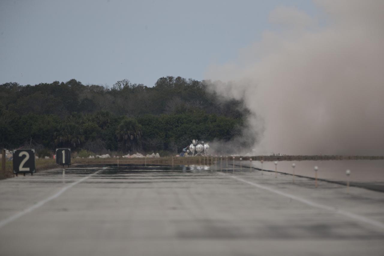 CAPE CANAVERAL, Fla. – The Project Morpheus prototype lander touches down in the autonomous landing and hazard avoidance technology, or ALHAT, hazard field after launching on its fourth free flight test at the north end of the Shuttle Landing Facility at NASA’s Kennedy Space Center in Florida. The 64-second test began at 1:15 p.m. EST with the Morpheus lander launching from the ground over a flame trench and ascending about 305 feet, significantly increasing the ascent velocity from the last test. The lander flew forward, covering about 358 feet in 25 seconds before descending and landing within 15 inches of its target on a dedicated pad inside the ALHAT hazard field. Project Morpheus tests NASA’s ALHAT and an engine that runs on liquid oxygen and methane, or green propellants, into a fully-operational lander that could deliver cargo to other planetary surfaces. The landing facility provides the lander with the kind of field necessary for realistic testing, complete with rocks, craters and hazards to avoid. Morpheus’ ALHAT payload allows it to navigate to clear landing sites amidst rocks, craters and other hazards during its descent. Project Morpheus is being managed under the Advanced Exploration Systems, or AES, Division in NASA’s Human Exploration and Operations Mission Directorate. The efforts in AES pioneer new approaches for rapidly developing prototype systems, demonstrating key capabilities and validating operational concepts for future human missions beyond Earth orbit. For more information on Project Morpheus, visit http://www.nasa.gov/centers/johnson/exploration/morpheus. Photo credit: NASA/Kim Shiflett