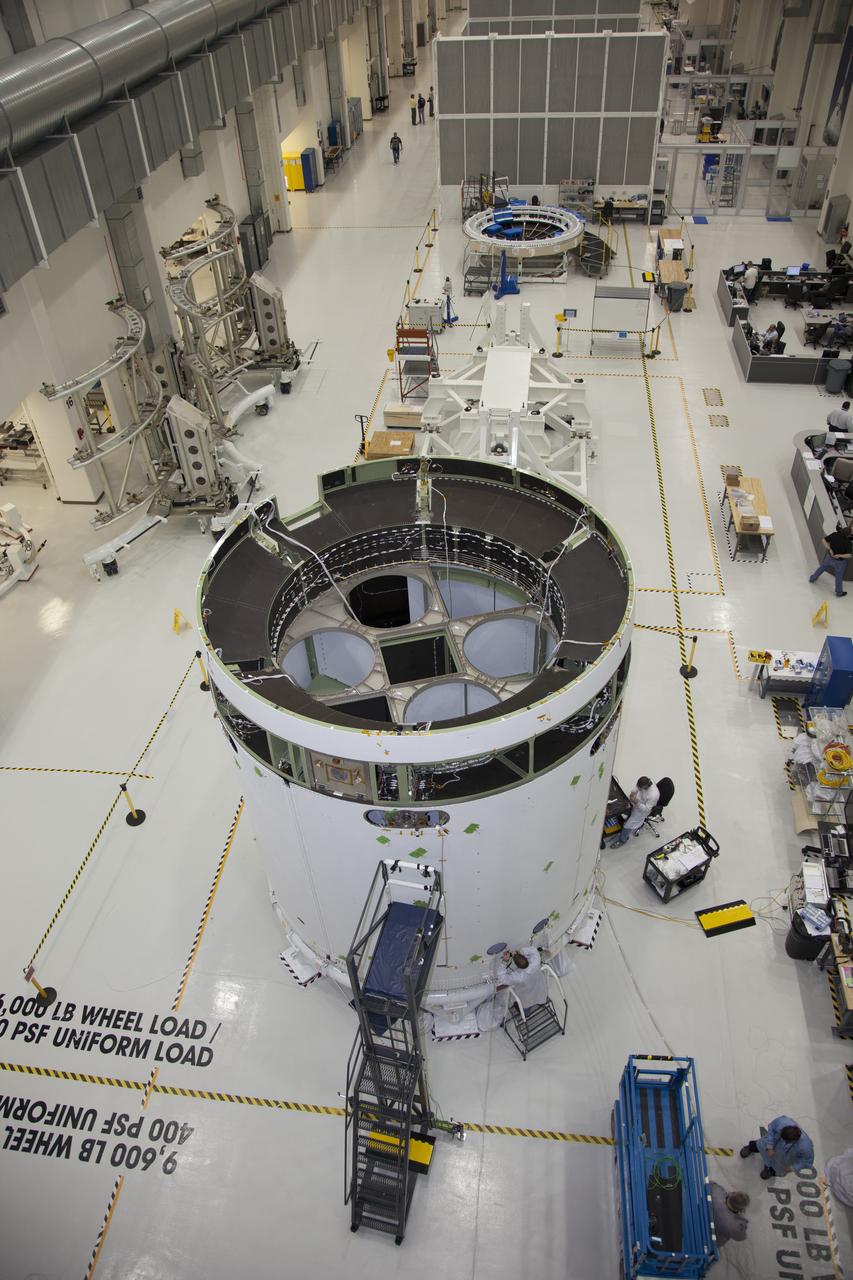 CAPE CANAVERAL, Fla. – A view from above inside the Operations and Checkout Building high bay at NASA’s Kennedy Space Center in Florida, shows the service module for the Orion spacecraft secured to a work stand. Technicians are completing the installation of the three fairings around the service module that will protect it during launch. The Orion spacecraft is being prepared for its first unpiloted flight test, Exploration Flight Test-1, or EFT-1, scheduled for launch atop a Delta IV rocket in September 2014. The Orion spacecraft is designed to carry astronauts to destinations not yet explored by humans. It will have emergency abort capability, sustain the crew during space travel and provide safe re-entry from deep space return velocities. Orion is scheduled to launch atop NASA’s Space Launch System rocket in 2017. For more information, visit http://www.nasa.gov/orion. Photo credit: NASA/Daniel Casper