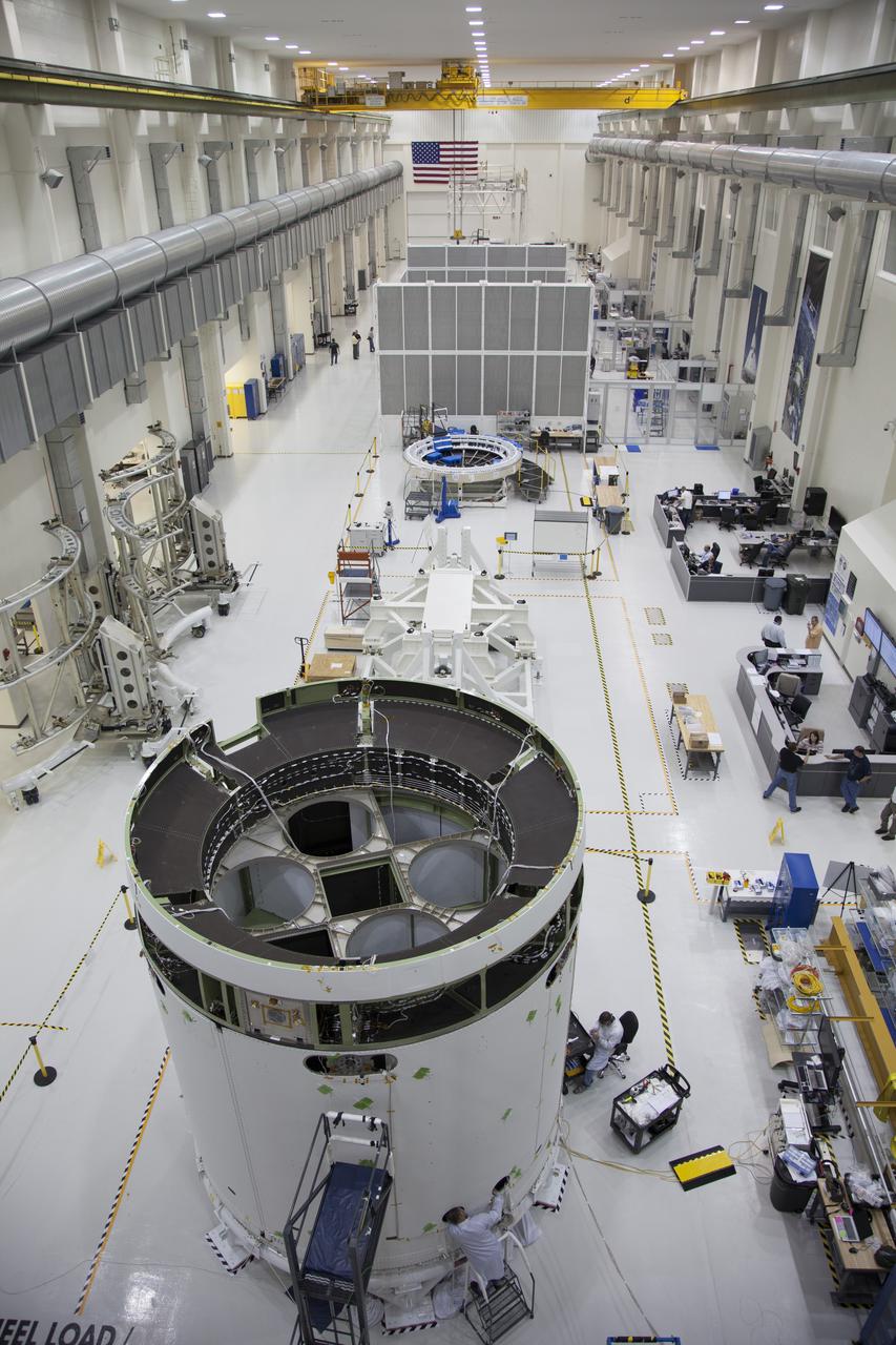 CAPE CANAVERAL, Fla. – A view from above inside the Operations and Checkout Building high bay at NASA’s Kennedy Space Center in Florida, shows the service module for the Orion spacecraft secured to a work stand. Technicians are completing the installation of the three fairings around the service module that will protect it during launch. The Orion spacecraft is being prepared for its first unpiloted flight test, Exploration Flight Test-1, or EFT-1, scheduled for launch atop a Delta IV rocket in September 2014. The Orion spacecraft is designed to carry astronauts to destinations not yet explored by humans. It will have emergency abort capability, sustain the crew during space travel and provide safe re-entry from deep space return velocities. Orion is scheduled to launch atop NASA’s Space Launch System rocket in 2017. For more information, visit http://www.nasa.gov/orion. Photo credit: NASA/Daniel Casper