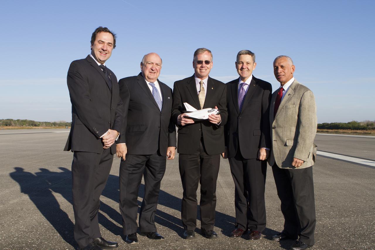 CAPE CANAVERAL, Fla. – NASA and aerospace industry representatives tour facilities along Florida’s Space Coast prior to announcements made by Sierra Nevada Corporation, or SNC, Space Systems, to prepare for a November 2016 orbital flight of its Dream Chaser spacecraft. Posing for a photo along the 3.5-mile-long runway at Kennedy Space Center’s Shuttle Landing Facility are, from left, Mark Sirangelo, corporate vice president and head of SNC Space Systems Frank DiBello, president and CEO of Space Florida Steve Lindsey, Dream Chaser program manager for SNC Space Systems Bob Cabana, director of NASA’s Kennedy Space Center and Charlie Bolden, administrator of NASA. The announcements made during a news conference at Kennedy are considered substantial for SNC and important to plans by NASA and Space Florida for Kennedy’s transformation into a multi-user spaceport for both commercial and government customers. SNC announced it plans to work with United Launch Alliance, or ULA, to launch the Dream Chaser spacecraft into orbit atop an Atlas V rocket from Space Launch Complex 41 at Cape Canaveral Air Force Station intends to land the winged spacecraft at the Shuttle Landing Facility lease office space at Exploration Park, right outside Kennedy’s gates and process the spacecraft in the high bay of the Operations and Checkout Building at Kennedy, with Lockheed Martin performing the work. Photo credit: NASA/Cory Huston