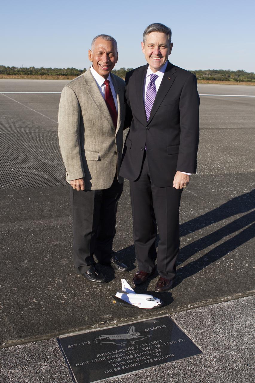 CAPE CANAVERAL, Fla. – NASA Administrator Charlie Bolden and Kennedy Space Center Director Bob Cabana pose for a photo at the plaque marking space shuttle Atlantis’ final mission, STS-135, along the 3.5-mile-long runway at Kennedy’s Shuttle Landing Facility. Also in the photo is a model of the Sierra Nevada Corporation, or SNC, Dream Chaser. SNC announced it plans to work with United Launch Alliance, or ULA, to launch the Dream Chaser spacecraft into orbit atop an Atlas V rocket from Space Launch Complex 41 at Cape Canaveral Air Force Station in November 2016 intends to land the winged spacecraft at the Shuttle Landing Facility lease office space at Exploration Park, right outside Kennedy’s gates and process the spacecraft in the high bay of the Operations and Checkout Building at Kennedy, with Lockheed Martin performing the work. The announcements made during a news conference at Kennedy are considered substantial for SNC and important to plans by NASA and Space Florida for Kennedy’s transformation into a multi-user spaceport for both commercial and government customers. Photo credit: NASA/Cory Huston