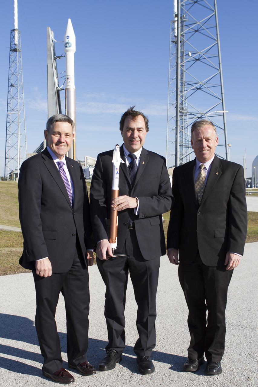 CAPE CANAVERAL, Fla. – NASA and aerospace industry representatives tour facilities along Florida’s Space Coast prior to announcements made by Sierra Nevada Corporation, or SNC, Space Systems, to prepare for a November 2016 orbital flight of its Dream Chaser spacecraft. Posing for a photo in front of a United Launch Alliance, or ULA, Atlas V rocket are, from left, Bob Cabana, director of NASA’s Kennedy Space Center Mark Sirangelo, corporate vice president and head of SNC Space Systems and Steve Lindsey, Dream Chaser program manager for SNC Space Systems. The announcements made during a news conference at Kennedy are considered substantial for SNC and important to plans by NASA and Space Florida for Kennedy’s transformation into a multi-user spaceport for both commercial and government customers. SNC announced it plans to work with ULA to launch the Dream Chaser spacecraft into orbit atop an Atlas V rocket from Space Launch Complex 41 at Cape Canaveral Air Force Station intends to land the winged spacecraft at the 3.5-mile-long runway at Kennedy’s Shuttle Landing Facility lease office space at Exploration Park, right outside Kennedy’s gates and process the spacecraft in the high bay of the Operations and Checkout Building at Kennedy, with Lockheed Martin performing the work. Photo credit: NASA/Cory Huston  