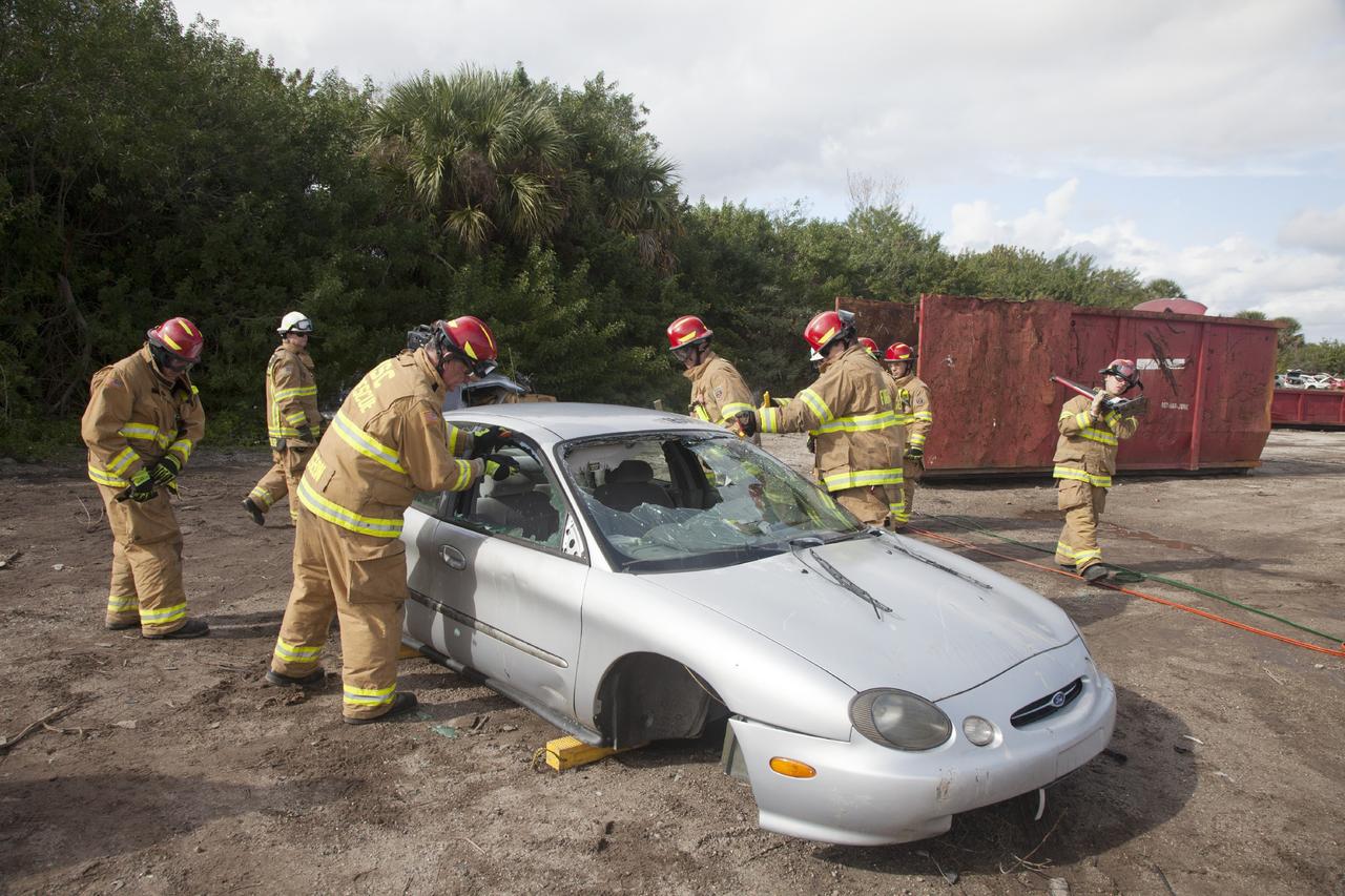 CAPE CANAVERAL, Fla. – Special Rescue Operations firefighters with NASA Fire Rescue Services in the Protective Services Office at NASA’s Kennedy Space Center in Florida practice vehicle extrication training at an auto salvage yard near the center. Stabilizing blocks have been placed underneath the car. Firefighters practiced knocking out the windshield and windows with axes and other tools. They will use the Jaws of Life on the vehicle to simulate the rescue of a trapped and injured person. Other rescue equipment includes a hydraulic cutting tool that is used to remove the roof of a car.    Kennedy’s firefighters recently achieved Pro Board Certification in aerial fire truck operations. With the completion of vehicle extrication and Jaws of Life training, the Protective Services Office is one step closer to achieving certification in vehicle machinery extrication. Kennedy’s firefighters are with G4S Government Solutions Inc., on the Kennedy Protective Services Contract. Photo credit: NASA/Daniel Casper
