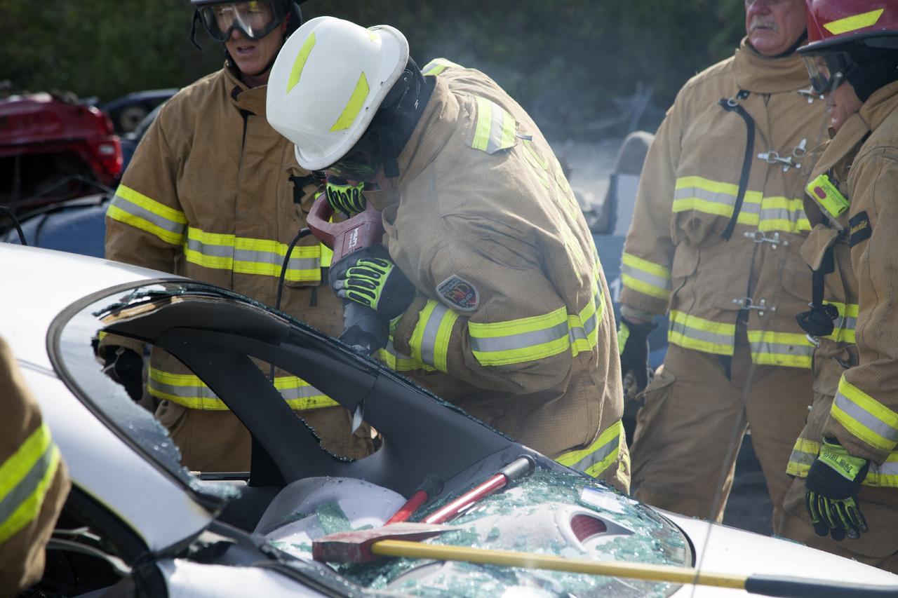 CAPE CANAVERAL, Fla. – Special Rescue Operations firefighters with NASA Fire Rescue Services in the Protective Services Office at NASA’s Kennedy Space Center in Florida practice vehicle extrication training at an auto salvage yard near the center. A firefighter uses a reciprocating saw to cut through a section of the car to remove the roof. Other firefighters used axes and special tools to punch through and clear away the windshield and windows. They will use the Jaws of Life to simulate the rescue of a trapped and injured person.     Kennedy’s firefighters recently achieved Pro Board Certification in aerial fire truck operations. With the completion of vehicle extrication and Jaws of Life training, the Protective Services Office is one step closer to achieving certification in vehicle machinery extrication. Kennedy’s firefighters are with G4S Government Solutions Inc., on the Kennedy Protective Services Contract. Photo credit: NASA/Daniel Casper