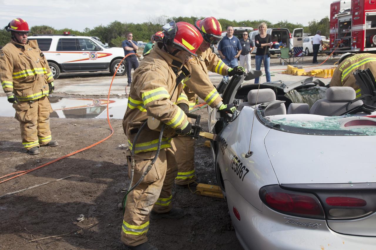 CAPE CANAVERAL, Fla. – Special Rescue Operations firefighters with NASA Fire Rescue Services in the Protective Services Office at NASA’s Kennedy Space Center in Florida practice vehicle extrication training at an auto salvage yard near the center. Firefighters have removed the roof of the car using a special hydraulic cutting tool and reciprocating saw. Other firefighters have used axes and special tools to punch through and clear away the windshield and windows. Another firefighter uses the Jaws of Life on the car to simulate the rescue of a trapped and injured person.    Kennedy’s firefighters recently achieved Pro Board Certification in aerial fire truck operations. With the completion of vehicle extrication and Jaws of Life training, the Protective Services Office is one step closer to achieving certification in vehicle machinery extrication. Kennedy’s firefighters are with G4S Government Solutions Inc., on the Kennedy Protective Services Contract. Photo credit: NASA/Daniel Casper