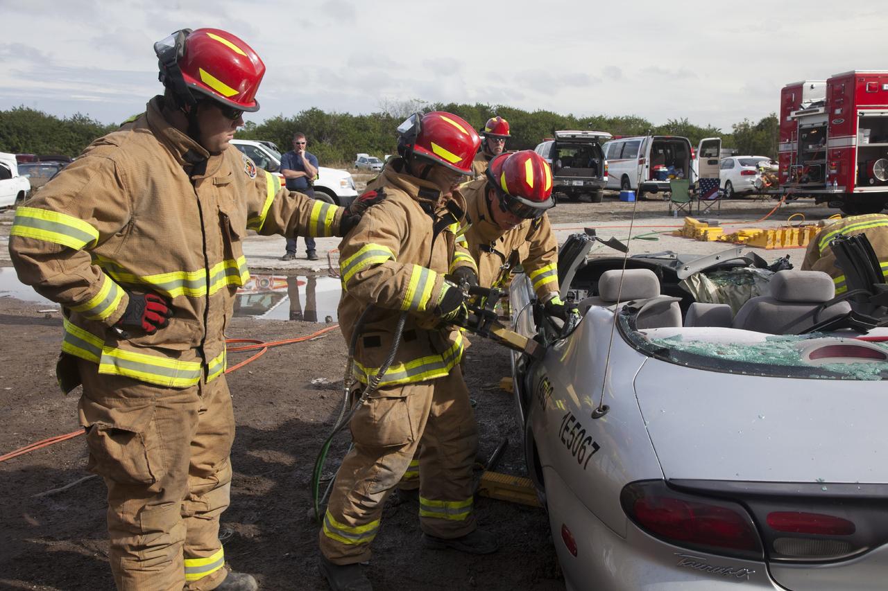 CAPE CANAVERAL, Fla. – Special Rescue Operations firefighters with NASA Fire Rescue Services in the Protective Services Office at NASA’s Kennedy Space Center in Florida practice vehicle extrication training at an auto salvage yard near the center. Two firefighters assist as another firefighter uses the Jaws of Life on the car to simulate the rescue of a trapped and injured person. A special hydraulic cutting tool and reciprocating saw were used to remove the roof of the vehicle. Other firefighters used axes and special tools to punch through and clear away the windshield and the windows.     Kennedy’s firefighters recently achieved Pro Board Certification in aerial fire truck operations. With the completion of vehicle extrication and Jaws of Life training, the Protective Services Office is one step closer to achieving certification in vehicle machinery extrication. Kennedy’s firefighters are with G4S Government Solutions Inc., on the Kennedy Protective Services Contract. Photo credit: NASA/Daniel Casper