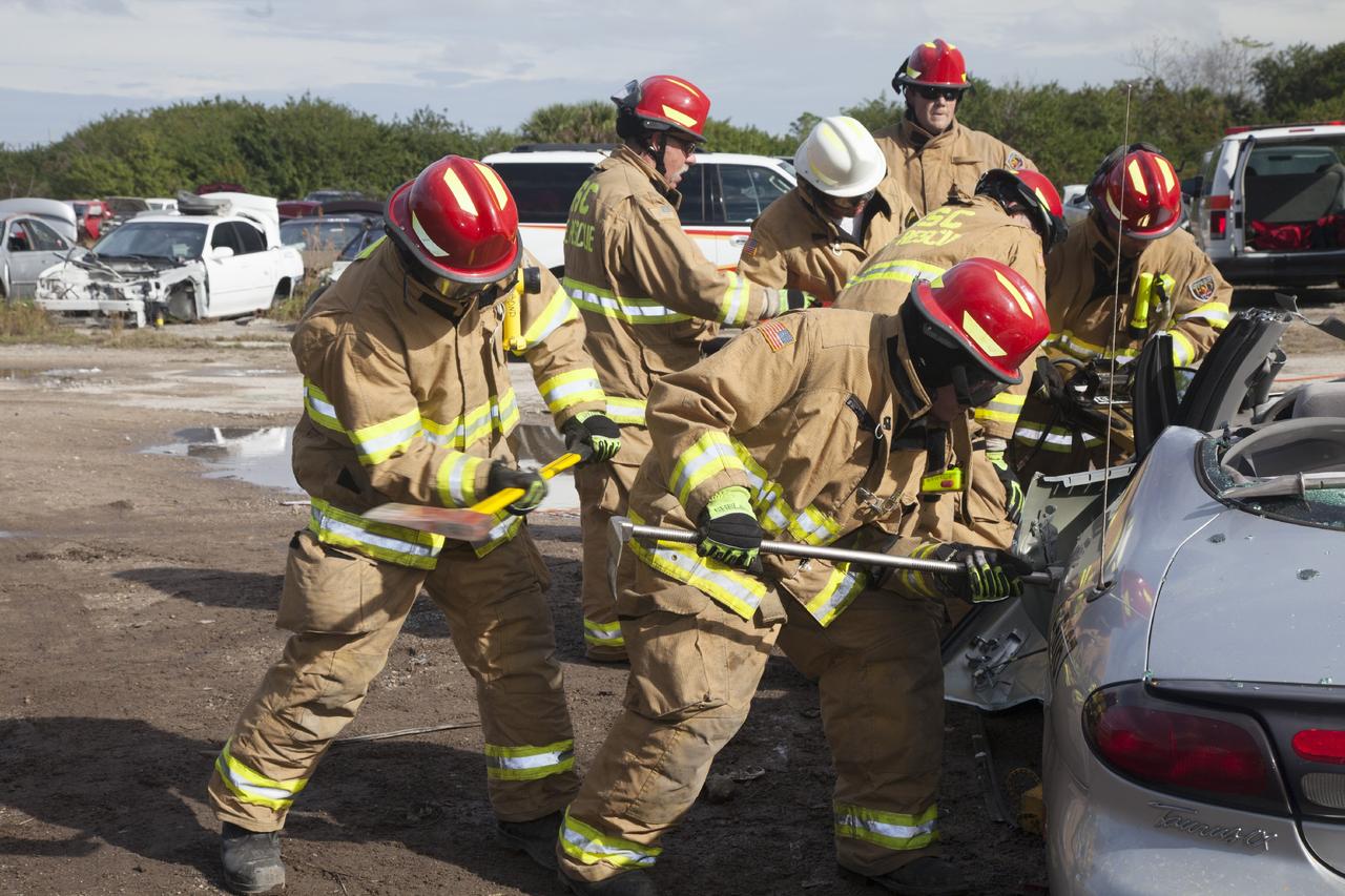 CAPE CANAVERAL, Fla. – Special Rescue Operations firefighters with NASA Fire Rescue Services in the Protective Services Office at NASA’s Kennedy Space Center in Florida practice vehicle extrication training at an auto salvage yard near the center. In the foreground, a firefighter with an axe assists as another firefighter uses a special tool to punch through the door of the vehicle. A special hydraulic cutting tool and reciprocating saw were used to cut through and remove the roof. In the background, other firefighters are practicing with the Jaws of Life to simulate the rescue of a trapped and injured person.     Kennedy’s firefighters recently achieved Pro Board Certification in aerial fire truck operations. With the completion of vehicle extrication and Jaws of Life training, the Protective Services Office is one step closer to achieving certification in vehicle machinery extrication. Kennedy’s firefighters are with G4S Government Solutions Inc., on the Kennedy Protective Services Contract. Photo credit: NASA/Daniel Casper