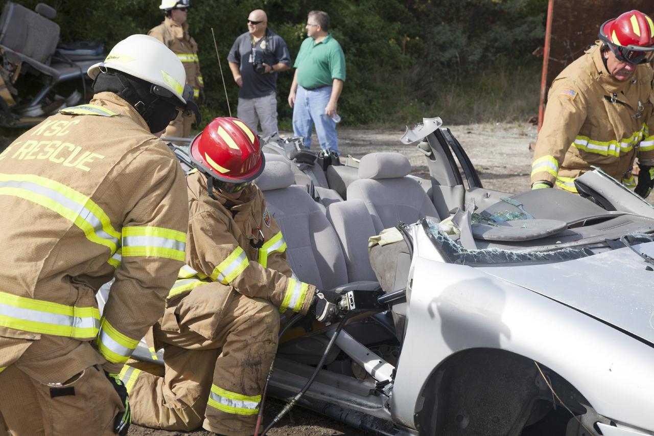 CAPE CANAVERAL, Fla. – Special Rescue Operations firefighters with NASA Fire Rescue Services in the Protective Services Office at NASA’s Kennedy Space Center in Florida practice vehicle extrication training at an auto salvage yard near the center. A firefighter uses a spreader to push the dashboard away from the seat. They used the Jaws of Life to remove the door from the vehicle and simulate the rescue of a trapped and injured person. A special hydraulic cutting tool and reciprocating saw were used to cut through and remove the roof. An axe and other special tools were used to punch through and clear away the windshield and windows.      Kennedy’s firefighters recently achieved Pro Board Certification in aerial fire truck operations. With the completion of vehicle extrication and Jaws of Life training, the Protective Services Office is one step closer to achieving certification in vehicle machinery extrication. Kennedy’s firefighters are with G4S Government Solutions Inc., on the Kennedy Protective Services Contract. Photo credit: NASA/Daniel Casper