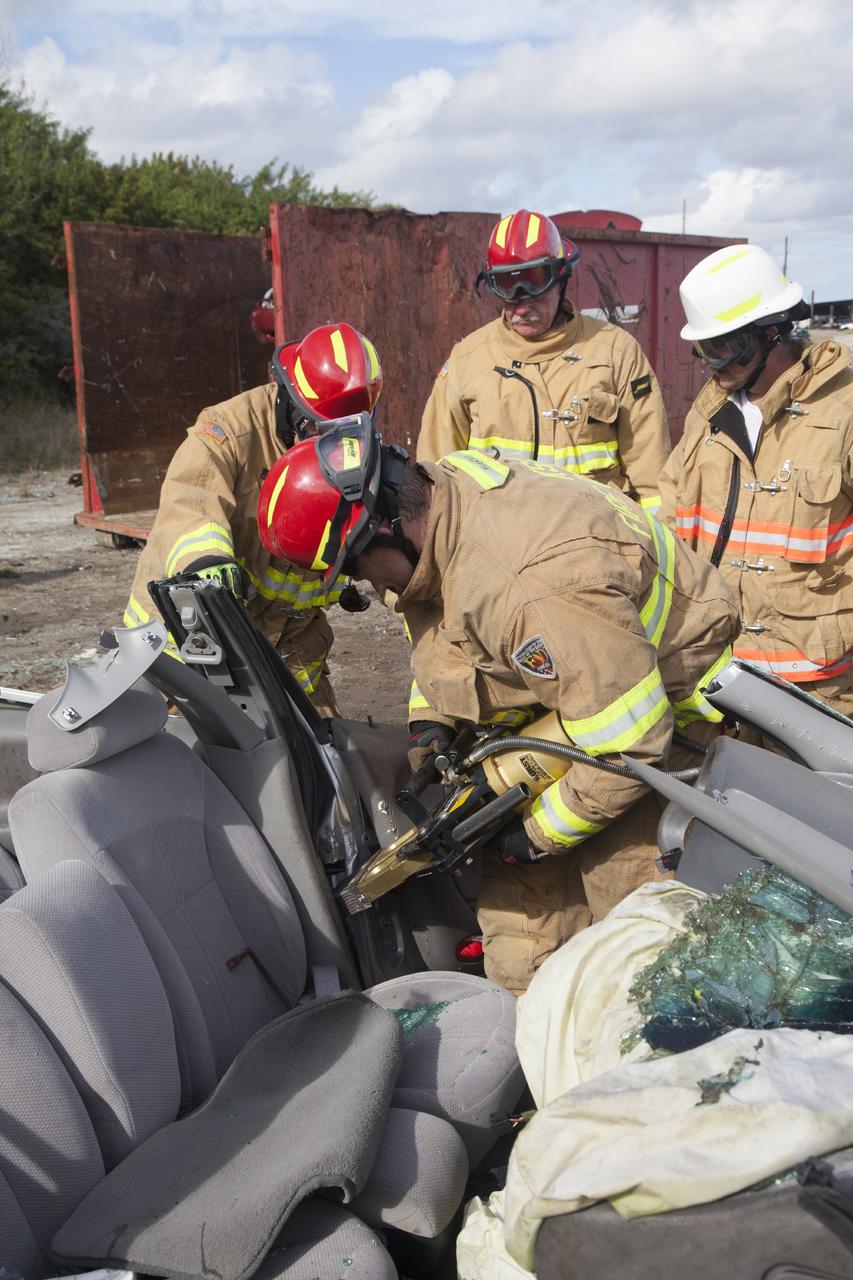CAPE CANAVERAL, Fla. – Special Rescue Operations firefighters with NASA Fire Rescue Services in the Protective Services Office at NASA’s Kennedy Space Center in Florida practice vehicle extrication training at an auto salvage yard near the center. A firefighter uses the Jaws of Life to finish removing the door from the vehicle and simulate the rescue of a trapped and injured person. A special hydraulic cutting tool and reciprocating saw were used to cut through and remove the roof. An axe and other special tools were used to punch through and clear away the windshield and windows.      Kennedy’s firefighters recently achieved Pro Board Certification in aerial fire truck operations. With the completion of vehicle extrication and Jaws of Life training, the Protective Services Office is one step closer to achieving certification in vehicle machinery extrication. Kennedy’s firefighters are with G4S Government Solutions Inc., on the Kennedy Protective Services Contract. Photo credit: NASA/Daniel Casper