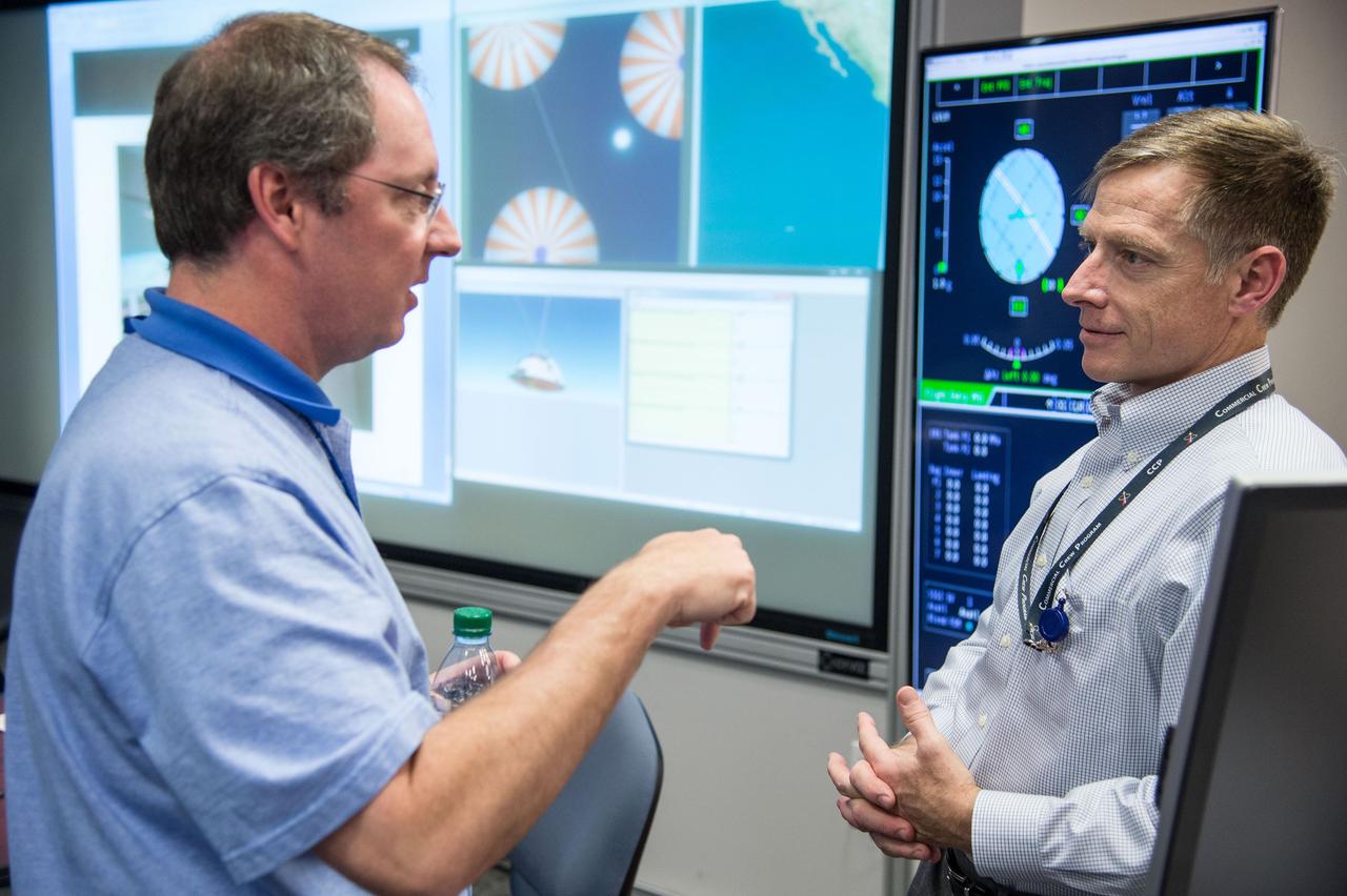 HOUSTON – Chris Ferguson, a former space shuttle commander who is now director of Crew and Mission Operations for Boeing Space Exploration, talks with an engineer following simulations that showed that the CST-100 software. Boeing demonstrated that the CST-100 software allows a human pilot to take over control of the spacecraft from the computer during all phases of a mission following separation from the launch vehicle. The pilot-in-the-loop demonstration at the Houston Product Support Center is a milestone under Boeing's Commercial Crew Integrated Capability agreement with the agency and its Commercial Crew Program. Photo credit: NASA/Bill Stafford