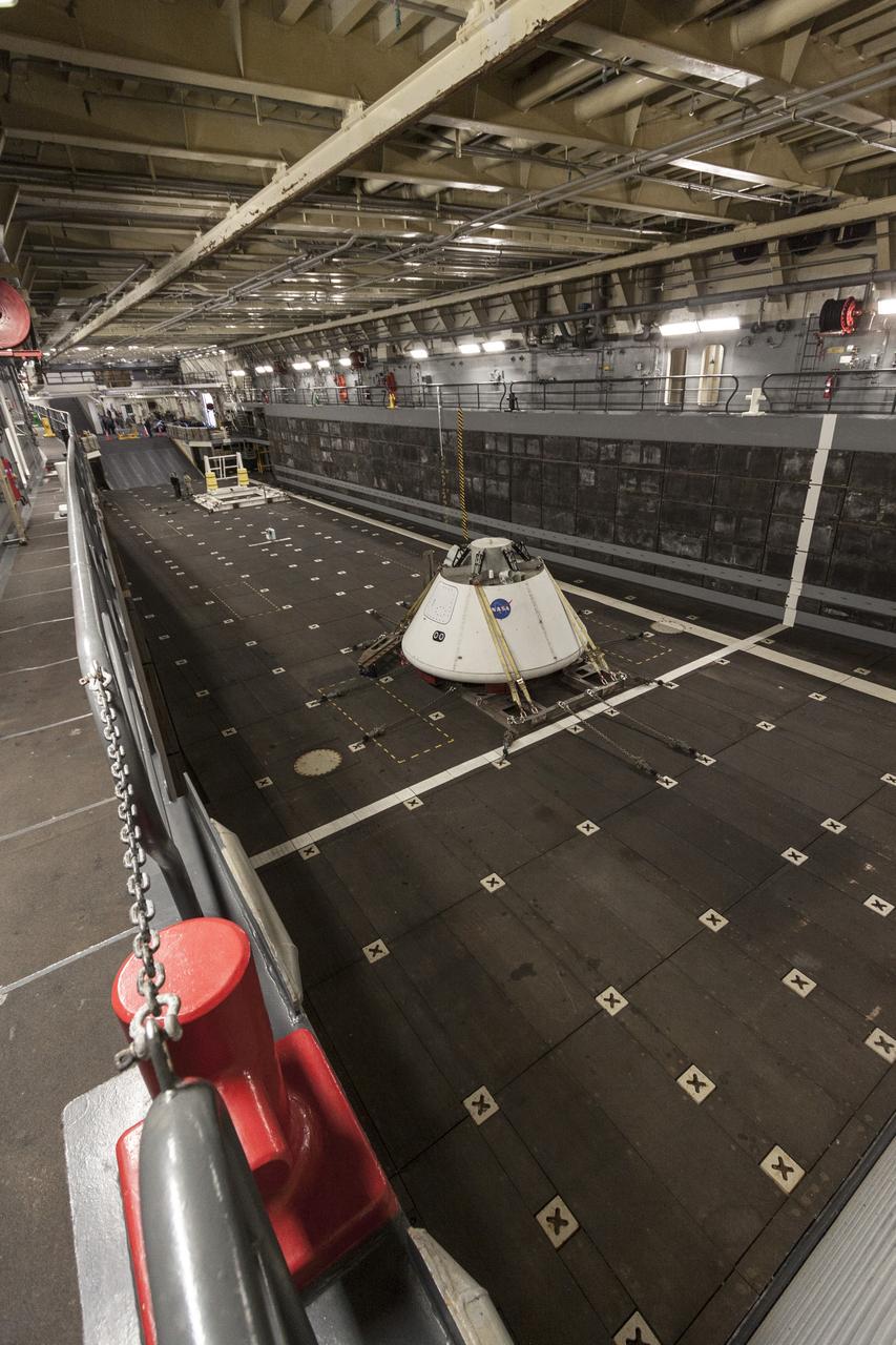 SAN DIEGO, Calif. – The Orion boilerplate test vehicle is secured in the well deck of the USS San Diego at the U.S. Naval Base San Diego in California. Orion was transported about 100 miles offshore for an underway recovery test. NASA and the U.S. Navy conducted tests to prepare for recovery of the Orion crew module, forward bay cover and parachutes on its return from a deep space mission. The underway recovery test will allow the teams to demonstrate and evaluate the recovery processes, procedures, hardware and personnel in open waters. During the testing, the tether lines were unable to support the tension caused by crew module motion that was driven by wave turbulence in the well deck of the ship. NASA and the U.S. Navy are reviewing the testing data collected to evaluate the next steps. The Ground Systems Development and Operations Program conducted the underway recovery tests. Orion is the exploration spacecraft designed to carry astronauts to destinations not yet explored by humans, including an asteroid and Mars. It will have emergency abort capability, sustain the crew during space travel and provide safe re-entry from deep space return velocities. The first unpiloted test flight of the Orion is scheduled to launch in 2014 atop a Delta IV rocket and in 2017 on NASA’s Space Launch System rocket. For more information, visit http://www.nasa.gov/orion. Photo credit: NASA/Cory Huston