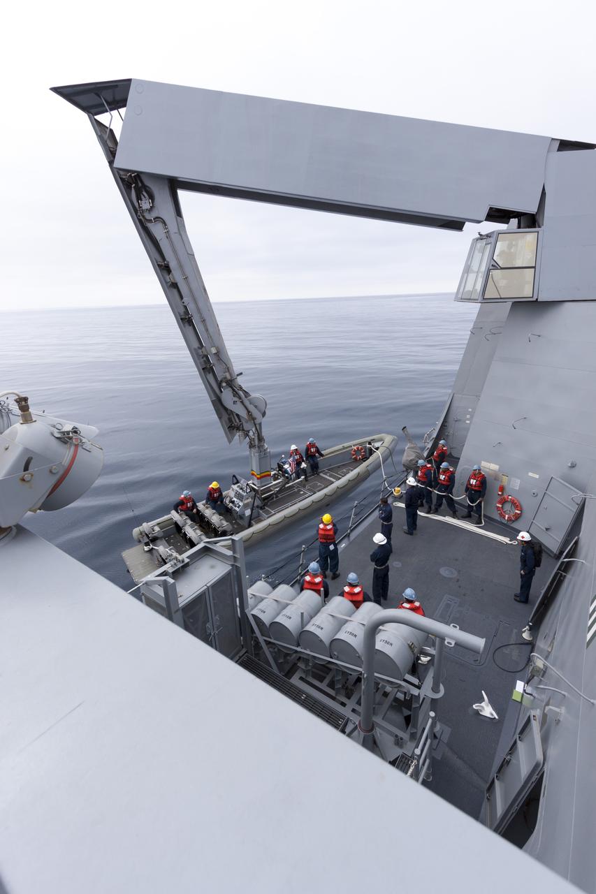 SAN DIEGO, Calif. – The USS San Diego heads out to sea with the Orion boilerplate test vehicle and other hardware in its well deck for an underway recovery test. A crane is used to lower a rigid hull inflatable boat into the water and U.S. Navy personnel have transferred from the ship to the smaller boat. About 100 miles offshore, NASA and the U.S. Navy conducted tests to prepare for recovery of the Orion crew module, forward bay cover and parachutes on its return from a deep space mission. The underway recovery test will allow the teams to demonstrate and evaluate the recovery processes, procedures, hardware and personnel in open waters. During the testing, the tether lines were unable to support the tension caused by crew module motion that was driven by wave turbulence in the well deck of the ship. NASA and the U.S. Navy are reviewing the testing data collected to evaluate the next steps. The Ground Systems Development and Operations Program conducted the underway recovery tests. Orion is the exploration spacecraft designed to carry astronauts to destinations not yet explored by humans, including an asteroid and Mars. It will have emergency abort capability, sustain the crew during space travel and provide safe re-entry from deep space return velocities. The first unpiloted test flight of the Orion is scheduled to launch in 2014 atop a Delta IV rocket and in 2017 on NASA’s Space Launch System rocket. For more information, visit http://www.nasa.gov/orion. Photo credit: NASA/Cory Huston  