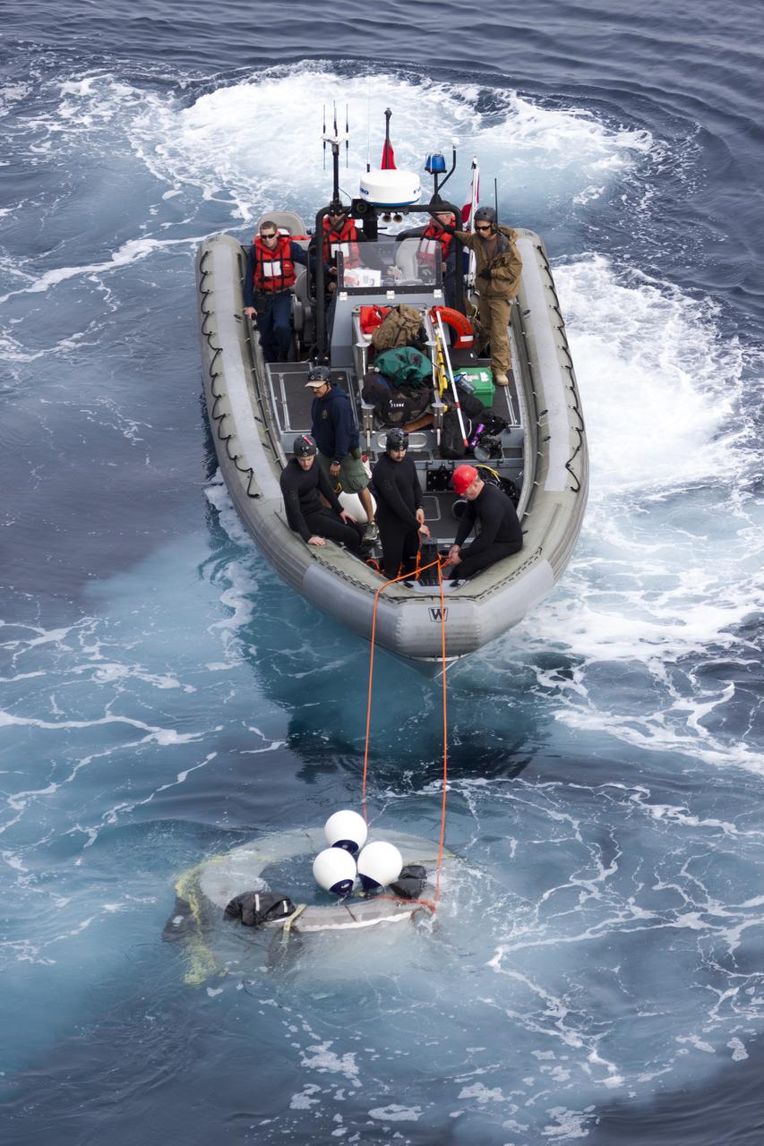 SAN DIEGO, Calif. – Using a rigid hull inflatable boat, NASA and the U.S. Navy practice retrieving the Orion forward bay cover from the Pacific Ocean as part of the Orion underway recovery test. The Orion boilerplate test vehicle and other hardware are secured in the well deck of the USS San Diego nearby in preparation for the test about 100 miles off the coast of San Diego, California. NASA and the U.S. Navy conducted tests to prepare for the recovery of the Orion crew module, forward bay cover and parachutes on its return from a deep space mission. The underway recovery test will allow the teams to demonstrate and evaluate the recovery processes, procedures, hardware and personnel in open waters. During the testing, the tether lines were unable to support the tension caused by crew module motion that was driven by wave turbulence in the well deck of the ship. NASA and the U.S. Navy called off the week’s remaining testing to allow engineers to evaluate the next steps The Ground Systems Development and Operations Program conducted the underway recovery tests. Orion is the exploration spacecraft designed to carry astronauts to destinations not yet explored by humans, including an asteroid and Mars. It will have emergency abort capability, sustain the crew during space travel and provide safe re-entry from deep space return velocities. The first unpiloted test flight of the Orion is scheduled to launch in 2014 atop a Delta IV rocket and in 2017 on NASA’s Space Launch System rocket. For more information, visit http://www.nasa.gov/orion. Photo credit: NASA/Cory Huston  