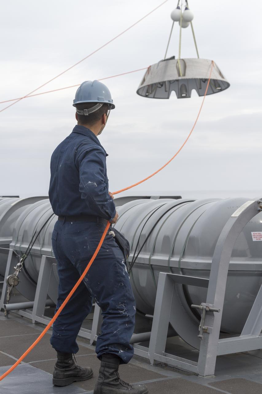 SAN DIEGO, Calif. – The Orion forward bay cover is lowered into the water using a crane and tether lines as part of the Orion underway recovery test. The Orion boilerplate test vehicle and other hardware are secured in the well deck of the USS San Diego in preparation for the test about 100 miles off the coast of San Diego, California. NASA and the U.S. Navy conducted tests to prepare for the recovery of the Orion crew module, forward bay cover and parachutes on its return from a deep space mission. The underway recovery test will allow the teams to demonstrate and evaluate the recovery processes, procedures, hardware and personnel in open waters. During the testing, the tether lines were unable to support the tension caused by crew module motion that was driven by wave turbulence in the well deck of the ship. NASA and the U.S. Navy are reviewing the testing data collected to evaluate the next steps. The Ground Systems Development and Operations Program conducted the underway recovery tests. Orion is the exploration spacecraft designed to carry astronauts to destinations not yet explored by humans, including an asteroid and Mars. It will have emergency abort capability, sustain the crew during space travel and provide safe re-entry from deep space return velocities. The first unpiloted test flight of the Orion is scheduled to launch in 2014 atop a Delta IV rocket and in 2017 on NASA’s Space Launch System rocket. For more information, visit http://www.nasa.gov/orion. Photo credit: NASA/Cory Huston