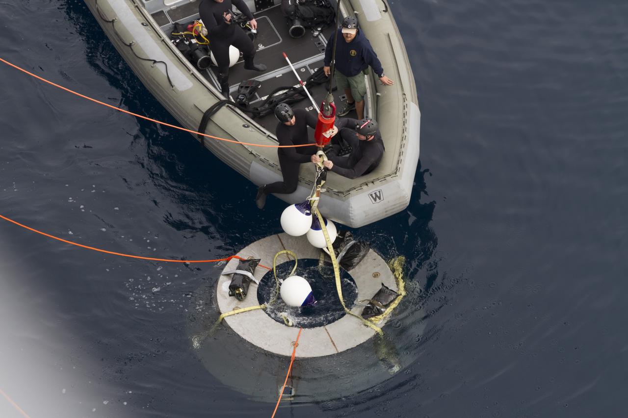 SAN DIEGO, Calif. – NASA and U.S. Navy personnel practice retrieving the Orion forward bay cover from the water during the Orion underway recovery test. The Orion boilerplate test vehicle and other hardware are secured in the well deck of the USS San Diego nearby in preparation for the test about 100 miles off the coast of San Diego, California. NASA and the U.S. Navy conducted tests to prepare for the recovery of the Orion crew module, forward bay cover and parachutes on its return from a deep space mission. The underway recovery test will allow the teams to demonstrate and evaluate the recovery processes, procedures, hardware and personnel in open waters. During the testing, the tether lines were unable to support the tension caused by crew module motion that was driven by wave turbulence in the well deck of the ship. NASA and the U.S. Navy are reviewing the testing data collected to evaluate the next steps. The Ground Systems Development and Operations Program conducted the underway recovery tests. Orion is the exploration spacecraft designed to carry astronauts to destinations not yet explored by humans, including an asteroid and Mars. It will have emergency abort capability, sustain the crew during space travel and provide safe re-entry from deep space return velocities. The first unpiloted test flight of the Orion is scheduled to launch in 2014 atop a Delta IV rocket and in 2017 on NASA’s Space Launch System rocket. For more information, visit http://www.nasa.gov/orion. Photo credit: NASA/Cory Huston