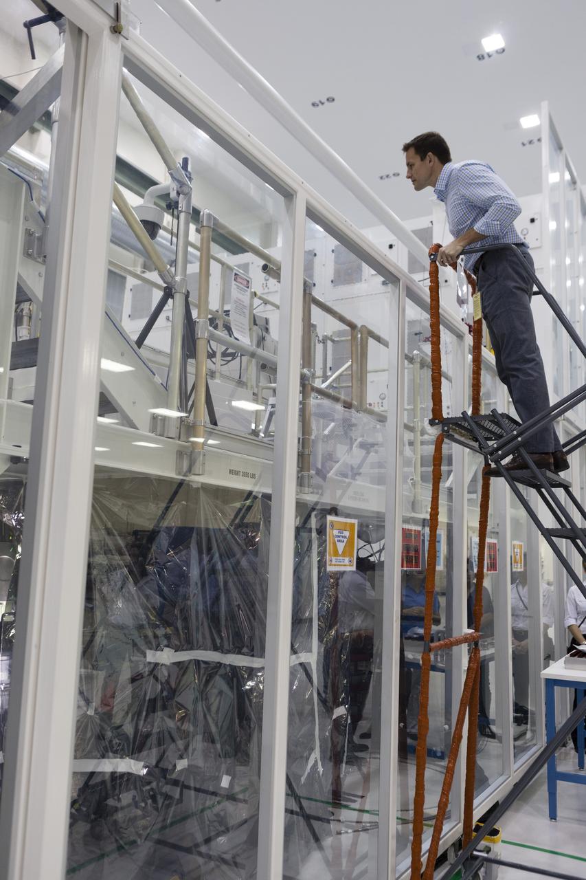 CAPE CANAVERAL, Fla. -- In the Operations and Checkout Building of NASA's Kennedy Space Center in Florida, astronaut candidate Josh Cassada looks over work platforms to gain a look at the Orion spacecraft being prepared for Exploration Flight Test EFT-1. Plans call for the Lockheed Martin-built Orion to launch atop a United Launch Alliance Delta IV Heavy rocket from Cape Canaveral Air Force Station. The astronaut class of 2013 was selected by NASA after an extensive year-and-a-half search. The new group will help the agency push the boundaries of exploration and travel to new destinations in the solar system. To learn more about the astronaut class of 2013, visit: http://www.nasa.gov/astronauts/2013astroclass.html Photo credit: NASA/Kim Shiflett