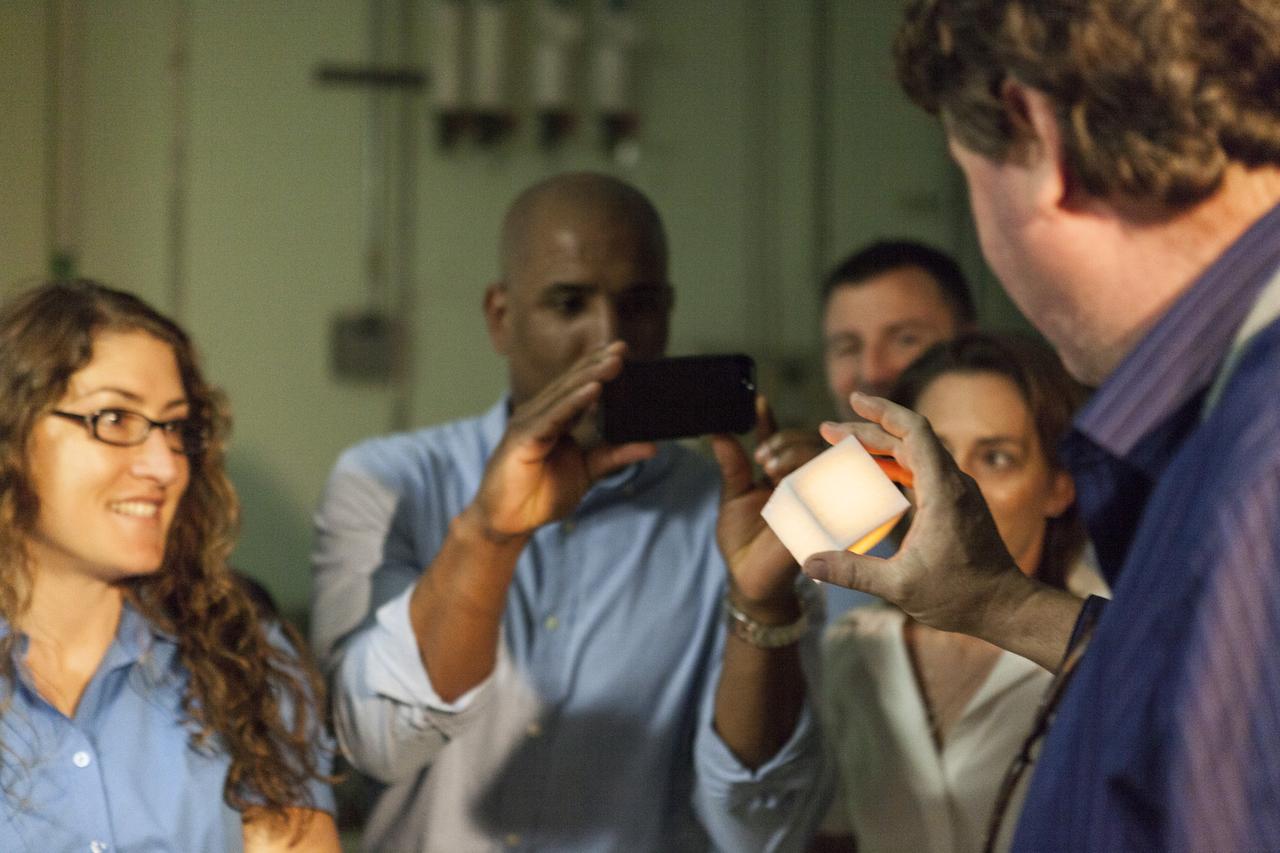 CAPE CANAVERAL, Fla. -- In the Thermal Protection System Facility NASA's Kennedy Space Center in Florida, agency astronaut candidates are briefed on tiles being manufactured for the agency's Orion spacecraft. TPSF manager, Martin Wilson of Jacobs Technology, holds a heated tile sample demonstrating its ability to protect a spacecraft during the heat of reentry. Looking on, from the left, are Christina Hammock, Victor Glover and Nicole Mann.  Plans call for the Lockheed Martin-built Orion to launch atop a United Launch Alliance Delta IV Heavy rocket from Cape Canaveral Air Force Station on Exploration Flight Test EFT-1 later this year. The astronaut class of 2013 was selected by NASA after an extensive year-and-a-half search. The new group will help the agency push the boundaries of exploration and travel to new destinations in the solar system. To learn more about the astronaut class of 2013, visit: http://www.nasa.gov/astronauts/2013astroclass.html Photo credit: NASA/Kim Shiflett