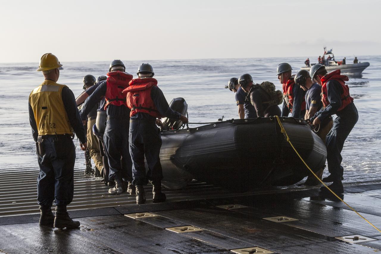 SAN DIEGO, Calif. – U.S. Navy personnel push a rigid hull inflatable boat from the well deck of the USS San Diego to conduct an Orion underway recovery test at sea with the Orion boilerplate test vehicle and other hardware. About 100 miles offshore, NASA and the U.S. Navy conducted tests to prepare for recovery of the Orion crew module, forward bay cover and parachutes on its return from a deep space mission. The underway recovery test allowed the teams to demonstrate and evaluate the recovery processes, procedures, hardware and personnel in open waters. During the testing, the tether lines were unable to support the tension caused by crew module motion that was driven by wave turbulence in the well deck of the ship. NASA and the U.S. Navy are reviewing the testing data collected to evaluate the next steps. The Ground Systems Development and Operations Program conducted the underway recovery tests. Orion is the exploration spacecraft designed to carry astronauts to destinations not yet explored by humans, including an asteroid and Mars. It will have emergency abort capability, sustain the crew during space travel and provide safe re-entry from deep space return velocities. The first unpiloted test flight of the Orion is scheduled to launch in 2014 atop a Delta IV rocket and in 2017 on NASA’s Space Launch System rocket. For more information, visit http://www.nasa.gov/orion. Photo credit: NASA/Cory Huston