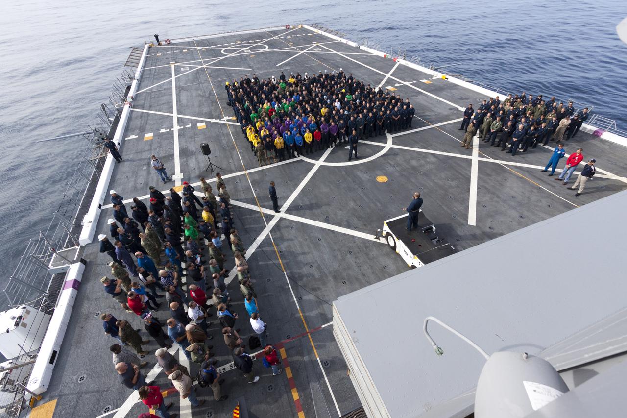 SAN DIEGO, Calif. – On the top deck of the USS San Diego, NASA and U.S. Navy personnel gather after the Orion underway recovery test. The Orion boilerplate test vehicle and other hardware were transported about 100 miles offshore for the recovery test. NASA and the U.S. Navy conducted tests to prepare for recovery of the Orion crew module, forward bay cover and parachutes on its return from a deep space mission. The underway recovery test will allow the teams to demonstrate and evaluate the recovery processes, procedures, hardware and personnel in open waters. During the testing, the tether lines were unable to support the tension caused by crew module motion that was driven by wave turbulence in the well deck of the ship. NASA and the U.S. Navy are reviewing the testing data collected to evaluate the next steps. The Ground Systems Development and Operations Program conducted the underway recovery tests. Orion is the exploration spacecraft designed to carry astronauts to destinations not yet explored by humans, including an asteroid and Mars. It will have emergency abort capability, sustain the crew during space travel and provide safe re-entry from deep space return velocities. The first unpiloted test flight of the Orion is scheduled to launch in 2014 atop a Delta IV rocket and in 2017 on NASA’s Space Launch System rocket. For more information, visit http://www.nasa.gov/orion. Photo credit: NASA/Cory Huston  