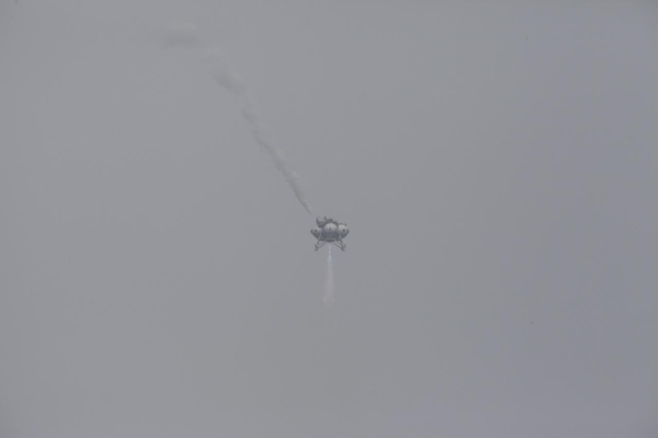 CAPE CANAVERAL, Fla. – The Project Morpheus prototype lander soars high and moves forward after launching on its sixth free flight test at the north end of the Shuttle Landing Facility at NASA’s Kennedy Space Center in Florida. The 82-second test began at 11:32 a.m. EST with the Morpheus lander launching from the ground over a flame trench and ascending to 465 feet. The lander flew forward, covering 633 feet while performing a 55-foot divert to emulate a hazard avoidance maneuver before descending and landing on a dedicated pad inside the automated landing and hazard avoidance technology, or ALHAT, hazard field. Morpheus landed 10 inches west of its intended target. Project Morpheus tests NASA’s ALHAT and an engine that runs on liquid oxygen and methane, or green propellants, into a fully-operational lander that could deliver cargo to other planetary surfaces. The landing facility provides the lander with the kind of field necessary for realistic testing, complete with rocks, craters and hazards to avoid. Morpheus’ ALHAT payload allows it to navigate to clear landing sites amidst rocks, craters and other hazards during its descent. Project Morpheus is being managed under the Advanced Exploration Systems, or AES, Division in NASA’s Human Exploration and Operations Mission Directorate. The efforts in AES pioneer new approaches for rapidly developing prototype systems, demonstrating key capabilities and validating operational concepts for future human missions beyond Earth orbit. For more information on Project Morpheus, visit http://morpheuslander.jsc.nasa.gov/. Photo credit: NASA/Kim Shiflett