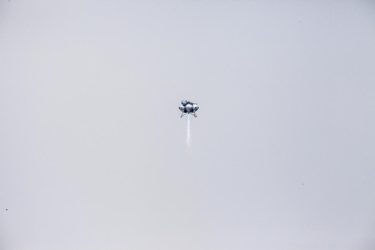 CAPE CANAVERAL, Fla. – The Project Morpheus prototype lander soars high after launching on its sixth free flight test at the north end of the Shuttle Landing Facility at NASA’s Kennedy Space Center in Florida. The 82-second test began at 11:32 a.m. EST with the Morpheus lander launching from the ground over a flame trench and ascending to 465 feet. The lander flew forward, covering 633 feet while performing a 55-foot divert to emulate a hazard avoidance maneuver before descending and landing on a dedicated pad inside the automated landing and hazard avoidance technology, or ALHAT, hazard field. Morpheus landed 10 inches west of its intended target. Project Morpheus tests NASA’s ALHAT and an engine that runs on liquid oxygen and methane, or green propellants, into a fully-operational lander that could deliver cargo to other planetary surfaces. The landing facility provides the lander with the kind of field necessary for realistic testing, complete with rocks, craters and hazards to avoid. Morpheus’ ALHAT payload allows it to navigate to clear landing sites amidst rocks, craters and other hazards during its descent. Project Morpheus is being managed under the Advanced Exploration Systems, or AES, Division in NASA’s Human Exploration and Operations Mission Directorate. The efforts in AES pioneer new approaches for rapidly developing prototype systems, demonstrating key capabilities and validating operational concepts for future human missions beyond Earth orbit. For more information on Project Morpheus, visit http://morpheuslander.jsc.nasa.gov/. Photo credit: NASA/Kim Shiflett