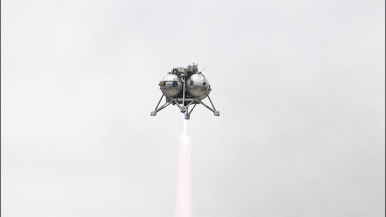 CAPE CANAVERAL, Fla. – The Project Morpheus prototype lander soars high after launching on its sixth free flight test at the north end of the Shuttle Landing Facility at NASA’s Kennedy Space Center in Florida. The 82-second test began at 11:32 a.m. EST with the Morpheus lander launching from the ground over a flame trench and ascending to 465 feet. The lander flew forward, covering 633 feet while performing a 55-foot divert to emulate a hazard avoidance maneuver before descending and landing on a dedicated pad inside the automated landing and hazard avoidance technology, or ALHAT, hazard field. Morpheus landed 10 inches west of its intended target. Project Morpheus tests NASA’s ALHAT and an engine that runs on liquid oxygen and methane, or green propellants, into a fully-operational lander that could deliver cargo to other planetary surfaces. The landing facility provides the lander with the kind of field necessary for realistic testing, complete with rocks, craters and hazards to avoid. Morpheus’ ALHAT payload allows it to navigate to clear landing sites amidst rocks, craters and other hazards during its descent. Project Morpheus is being managed under the Advanced Exploration Systems, or AES, Division in NASA’s Human Exploration and Operations Mission Directorate. The efforts in AES pioneer new approaches for rapidly developing prototype systems, demonstrating key capabilities and validating operational concepts for future human missions beyond Earth orbit. For more information on Project Morpheus, visit http://morpheuslander.jsc.nasa.gov/. Photo credit: NASA/Frankie Martin