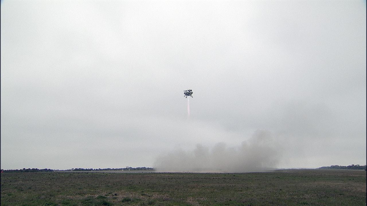 CAPE CANAVERAL, Fla. – The Project Morpheus prototype lander soars high after launching on its sixth free flight test at the north end of the Shuttle Landing Facility at NASA’s Kennedy Space Center in Florida. The 82-second test began at 11:32 a.m. EST with the Morpheus lander launching from the ground over a flame trench and ascending to 465 feet. The lander flew forward, covering 633 feet while performing a 55-foot divert to emulate a hazard avoidance maneuver before descending and landing on a dedicated pad inside the automated landing and hazard avoidance technology, or ALHAT, hazard field. Morpheus landed 10 inches west of its intended target. Project Morpheus tests NASA’s ALHAT and an engine that runs on liquid oxygen and methane, or green propellants, into a fully-operational lander that could deliver cargo to other planetary surfaces. The landing facility provides the lander with the kind of field necessary for realistic testing, complete with rocks, craters and hazards to avoid. Morpheus’ ALHAT payload allows it to navigate to clear landing sites amidst rocks, craters and other hazards during its descent. Project Morpheus is being managed under the Advanced Exploration Systems, or AES, Division in NASA’s Human Exploration and Operations Mission Directorate. The efforts in AES pioneer new approaches for rapidly developing prototype systems, demonstrating key capabilities and validating operational concepts for future human missions beyond Earth orbit. For more information on Project Morpheus, visit http://morpheuslander.jsc.nasa.gov/. Photo credit: NASA/Frankie Martin