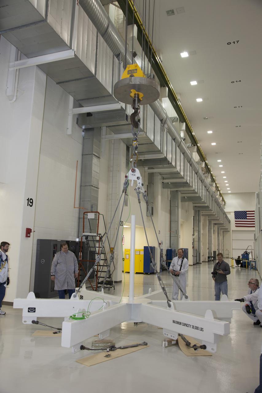 CAPE CANAVERAL, Fla. - Inside the Operations and Checkout Building high bay at NASA’s Kennedy Space Center in Florida, technicians monitor the progress as a crane lifts a ground support tool that will be used to transfer the service module for the Orion spacecraft to a static test stand. Orion is the exploration spacecraft designed to carry astronauts to destinations not yet explored by humans, including an asteroid and Mars. It will have emergency abort capability, sustain the crew during space travel and provide safe re-entry from deep space return velocities. The first unpiloted test flight of the Orion is scheduled to launch in 2014 atop a Delta IV rocket and in 2017 on NASA’s Space Launch System rocket. For more information, visit http://www.nasa.gov/orion. Photo credit: NASA/Daniel Casper