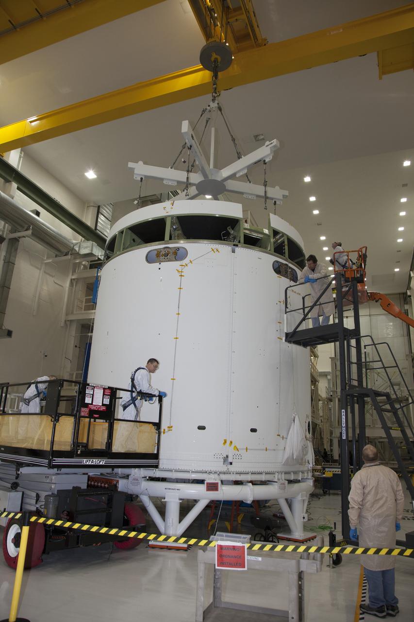 CAPE CANAVERAL, Fla. - Inside the Operations and Checkout Building high bay at NASA’s Kennedy Space Center in Florida, a crane lowers a ground support tool toward the service module for the Orion spacecraft. The service module will be transferred to a static test stand. Orion is the exploration spacecraft designed to carry astronauts to destinations not yet explored by humans, including an asteroid and Mars. It will have emergency abort capability, sustain the crew during space travel and provide safe re-entry from deep space return velocities. The first unpiloted test flight of the Orion is scheduled to launch in 2014 atop a Delta IV rocket and in 2017 on NASA’s Space Launch System rocket. For more information, visit http://www.nasa.gov/orion. Photo credit: NASA/Daniel Casper
