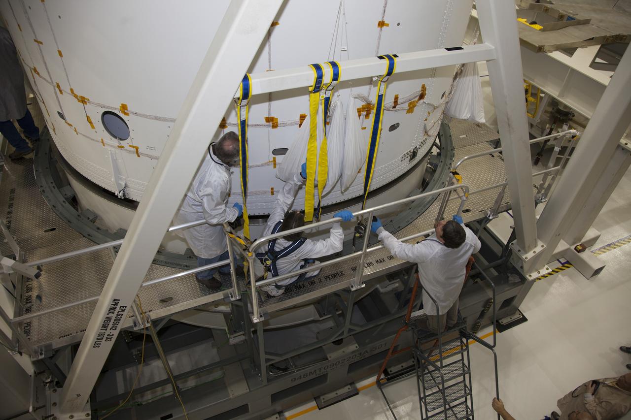 CAPE CANAVERAL, Fla. - Inside the Operations and Checkout Building high bay at NASA’s Kennedy Space Center in Florida, technicians on a platform monitor the progress as a crane lowers the service module for the Orion spacecraft onto a static test stand. Orion is the exploration spacecraft designed to carry astronauts to destinations not yet explored by humans, including an asteroid and Mars. It will have emergency abort capability, sustain the crew during space travel and provide safe re-entry from deep space return velocities. The first unpiloted test flight of the Orion is scheduled to launch in 2014 atop a Delta IV rocket and in 2017 on NASA’s Space Launch System rocket. For more information, visit http://www.nasa.gov/orion. Photo credit: NASA/Daniel Casper