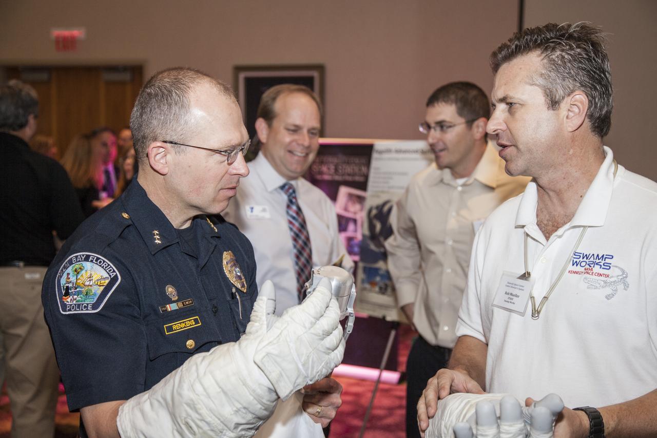 CAPE CANAVERAL, Fla. - Community leaders, business executives, educators, and state and local government leaders were updated on NASA Kennedy Space Center programs and accomplishments during Center Director Bob Cabana’s Center Director Update at the Debus Center at the Kennedy Space Center Visitor Complex in Florida. Rob Mueller, senior technologist, talks with attendees at the Swamp Works display. Attendees talked with Cabana and other senior Kennedy managers and visited displays featuring updates on Kennedy programs and projects, including International Space Station, Commercial Crew, Ground System Development and Operations, Launch Services, Center Planning and Development, Technology, KSC Swamp Works and NASA Education. The morning concluded with a tour of the new Space Shuttle Atlantis exhibit at the visitor complex. For more information, visit http://www.nasa.gov/kennedy. Photo credit: NASA/Daniel Casper