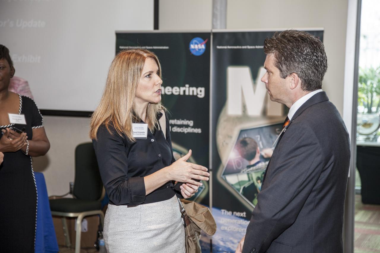 CAPE CANAVERAL, Fla. - Community leaders, business executives, educators, and state and local government leaders were updated on NASA Kennedy Space Center programs and accomplishments during Center Director Bob Cabana’s Center Director Update at the Debus Center at the Kennedy Space Center Visitor Complex in Florida. At left, Susan Fernandez from the Office of Senator Marco Rubio talks with another attendee near the Education display. Attendees talked with Cabana and other senior Kennedy managers and visited displays featuring updates on Kennedy programs and projects, including International Space Station, Commercial Crew, Ground System Development and Operations, Launch Services, Center Planning and Development, Technology, KSC Swamp Works and NASA Education. The morning concluded with a tour of the new Space Shuttle Atlantis exhibit at the visitor complex. For more information, visit http://www.nasa.gov/kennedy. Photo credit: NASA/Daniel Casper