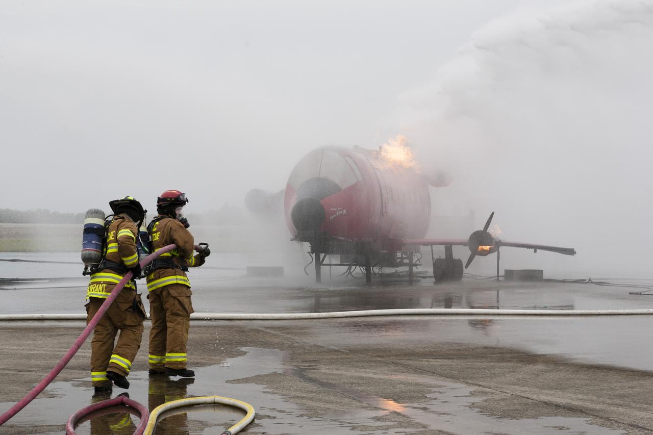 CAPE CANAVERAL, Fla. - During a training exercise, Special Rescue Operations firefighters with NASA Fire Rescue Services in the Protective Services Office at NASA’s Kennedy Space Center in Florida use hoses to put out a fire burning on a mock-up of a small plane at the Shuttle Landing Facility. They are wearing protective gear for the training exercise. Kennedy’s firefighters recently achieved Pro Board Certification in aerial fire truck operations and completed vehicle extrication training using the Jaws of Life. The Protective Services Office is one step closer to achieving certification in vehicle machinery extrication and other rescue skills. Kennedy’s firefighters are with G4S Government Solutions Inc., on the Kennedy Protective Services Contract. Photo credit: NASA/Kim Shiflett