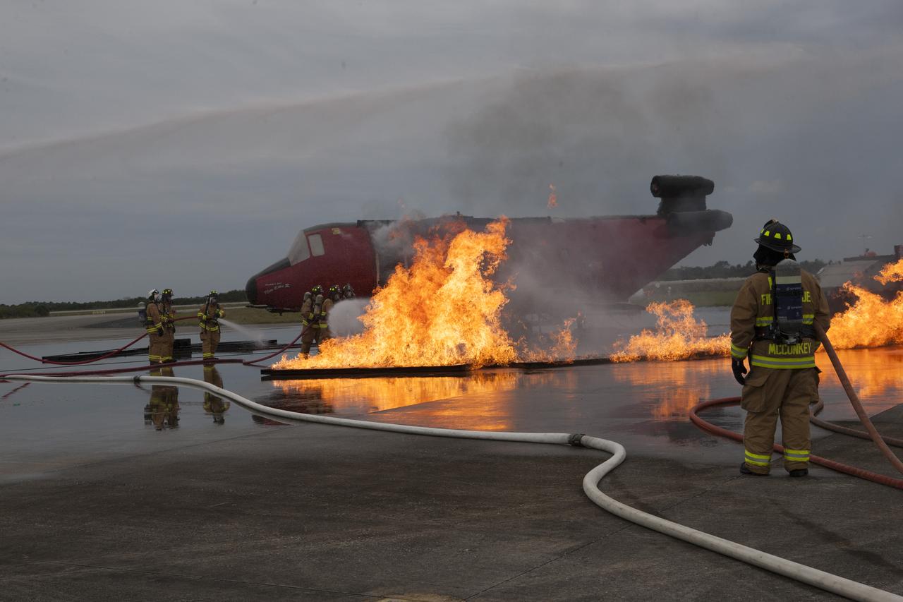 CAPE CANAVERAL, Fla. - Special Rescue Operations firefighters with NASA Fire Rescue Services in the Protective Services Office at NASA’s Kennedy Space Center in Florida participate in a training exercise at the Shuttle Landing Facility. Firefighters, wearing protective gear, use hoses to put out a fire burning near the mock-up of a small plane. Kennedy’s firefighters recently achieved Pro Board Certification in aerial fire truck operations and completed vehicle extrication training using the Jaws of Life. The Protective Services Office is one step closer to achieving certification in vehicle machinery extrication and other rescue skills. Kennedy’s firefighters are with G4S Government Solutions Inc., on the Kennedy Protective Services Contract. Photo credit: NASA/Kim Shiflett