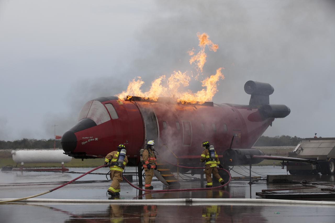 CAPE CANAVERAL, Fla. - Special Rescue Operations firefighters with NASA Fire Rescue Services in the Protective Services Office at NASA’s Kennedy Space Center in Florida participate in a training exercise at the Shuttle Landing Facility. Firefighters, wearing protective gear, use hoses to put out a fire burning on a mock-up of a small plane. Kennedy’s firefighters recently achieved Pro Board Certification in aerial fire truck operations and completed vehicle extrication training using the Jaws of Life. The Protective Services Office is one step closer to achieving certification in vehicle machinery extrication and other rescue skills. Kennedy’s firefighters are with G4S Government Solutions Inc., on the Kennedy Protective Services Contract. Photo credit: NASA/Kim Shiflett