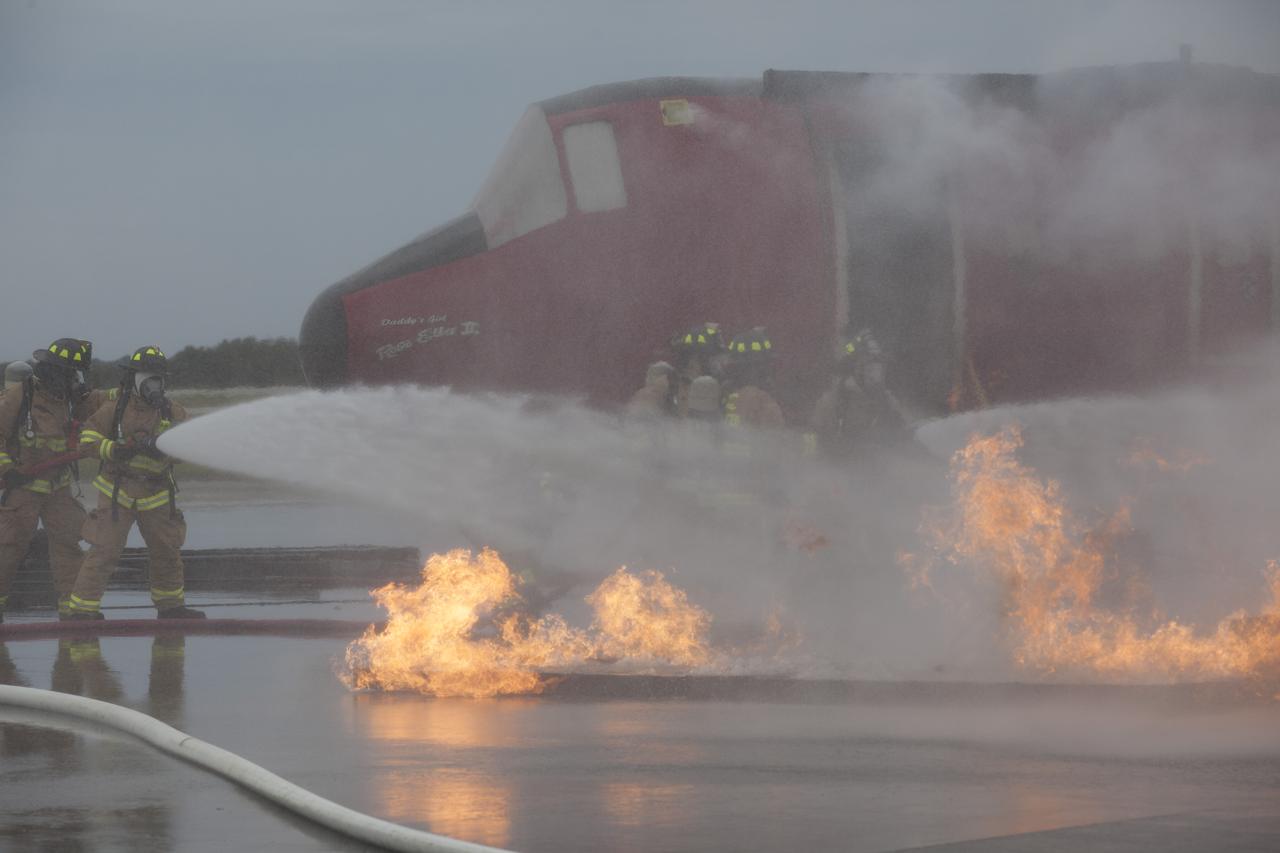 CAPE CANAVERAL, Fla. - Special Rescue Operations firefighters with NASA Fire Rescue Services in the Protective Services Office at NASA’s Kennedy Space Center in Florida participate in a training exercise at the Shuttle Landing Facility. Firefighters, wearing protective gear, use hoses to put out a fire burning close to a mock-up of a small plane. Kennedy’s firefighters recently achieved Pro Board Certification in aerial fire truck operations and completed vehicle extrication training using the Jaws of Life. The Protective Services Office is one step closer to achieving certification in vehicle machinery extrication and other rescue skills. Kennedy’s firefighters are with G4S Government Solutions Inc., on the Kennedy Protective Services Contract. Photo credit: NASA/Kim Shiflett