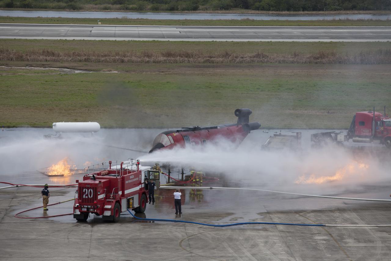 CAPE CANAVERAL, Fla. - Special Rescue Operations firefighters with NASA Fire Rescue Services in the Protective Services Office at NASA’s Kennedy Space Center in Florida participate in a training exercise at the Shuttle Landing Facility. Firefighters use a fire truck to put out a fire burning close to a mock-up of a small plane and a truck. Kennedy’s firefighters recently achieved Pro Board Certification in aerial fire truck operations and completed vehicle extrication training using the Jaws of Life. The Protective Services Office is one step closer to achieving certification in vehicle machinery extrication and other rescue skills. Kennedy’s firefighters are with G4S Government Solutions Inc., on the Kennedy Protective Services Contract. Photo credit: NASA/Kim Shiflett