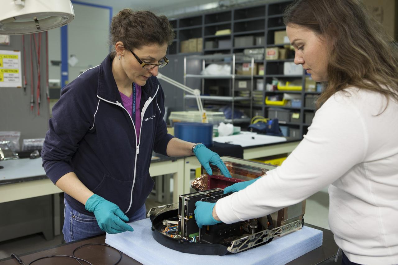 CAPE CANAVERAL, Fla. - In the Space Station Processing Facility at NASA's Kennedy Space Center in Florida, QinetiQ North America Project Manager Carole Miller, left, works with Allison Caron, a QinetiQ mechanical engineer in preparing the Biotube experiment which will be launched to the International Space Station aboard a SpaceX Dragon spacecraft. Scheduled for launch on March 16 atop a Falcon 9 rocket, Dragon will be marking its fourth trip to the space station. The SpaceX-3 mission is the third of 12 flights contracted by NASA to resupply the orbiting laboratory. For more information, visit http://www.nasa.gov/mission_pages/station/structure/launch/index.html Photo credit: NASA/Kim Shiflett