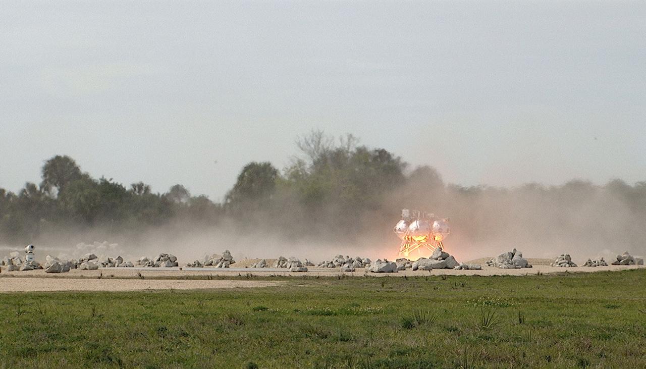 CAPE CANAVERAL, Fla. - The Project Morpheus prototype lander touches down in the automated landing and hazard avoidance technology, or ALHAT, hazard field after completing its seventh free flight test at the north end of the Shuttle Landing Facility at NASA’s Kennedy Space Center in Florida. The 83-second test began at 3:41 p.m. EDT with the Morpheus lander launching from the ground over a flame trench and ascending to 580 feet, its highest to date. Morpheus then flew its fastest downrange trek at 30 mph, travelling farther than before, 837 feet. The lander performed a 42-foot divert to emulate a hazard avoidance maneuver before descending and touching down on Landing Site 2, at the northern landing pad inside the hazard field. Morpheus landed within one foot of its intended target. Project Morpheus tests NASA’s ALHAT and an engine that runs on liquid oxygen and methane, or green propellants, into a fully-operational lander that could deliver cargo to other planetary surfaces. The landing facility provides the lander with the kind of field necessary for realistic testing, complete with rocks, craters and hazards to avoid. Morpheus’ ALHAT payload allows it to navigate to clear landing sites amidst rocks, craters and other hazards during its descent. Project Morpheus is being managed under the Advanced Exploration Systems, or AES, Division in NASA’s Human Exploration and Operations Mission Directorate. The efforts in AES pioneer new approaches for rapidly developing prototype systems, demonstrating key capabilities and validating operational concepts for future human missions beyond Earth orbit. For more information on Project Morpheus, visit http://morpheuslander.jsc.nasa.gov/. Photo credit: NASA/Mike Chambers
