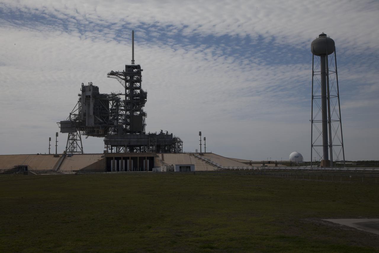 CAPE CANAVERAL, Fla. -- At NASA's Kennedy Space Center in Florida, launch pad 39A looks much like it did after the liftoff of STS-135, the final space shuttle mission, on July 8, 2011. The mobile launcher platform remains in place next to the fixed service structure and rotating service structure. During the shuttle program, water was stored in the 290-foot-high, 300,000 gallon tank on the right. Water was released just prior to the main engine ignition and flows by gravity to special outlets on the platform to protect the orbiter and its payloads from being damaged by acoustical energy reflected from the platform during liftoff. Both launch pad 39A and 39B pad 39A was originally built for the Apollo/Saturn V rockets that launched American astronauts on their historic journeys to the moon and later modified to support the 30-year shuttle program. To learn more about Launch Pad 39A visit: http://www.nasa.gov/mission_pages/shuttle/launch/launch-complex39-toc.html Photo credit: NASA/Dan Casper