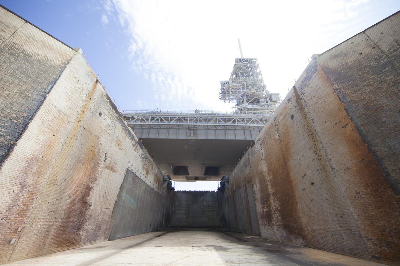 CAPE CANAVERAL, Fla. -- At NASA's Kennedy Space Center in Florida, launch pad 39A looks much like it did after the liftoff of STS-135, the final space shuttle mission, on July 8, 2011. This view shows the flame trench where smoke and flame from the shuttle's twin solid rocket boosters were deflected away from the pad. Both launch pad 39A and 39B pad 39A was originally built for the Apollo/Saturn V rockets that launched American astronauts on their historic journeys to the moon and later modified to support the 30-year shuttle program. To learn more about Launch Pad 39A visit: http://www.nasa.gov/mission_pages/shuttle/launch/launch-complex39-toc.html Photo credit: NASA/Dan Casper